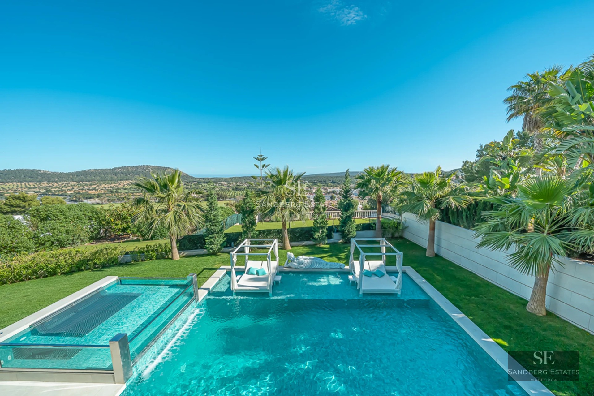 Spacious balcony overlooking the sea. Elegant outdoor furniture with armchairs and coffee table. Glass railing maximizes the panoramic view.