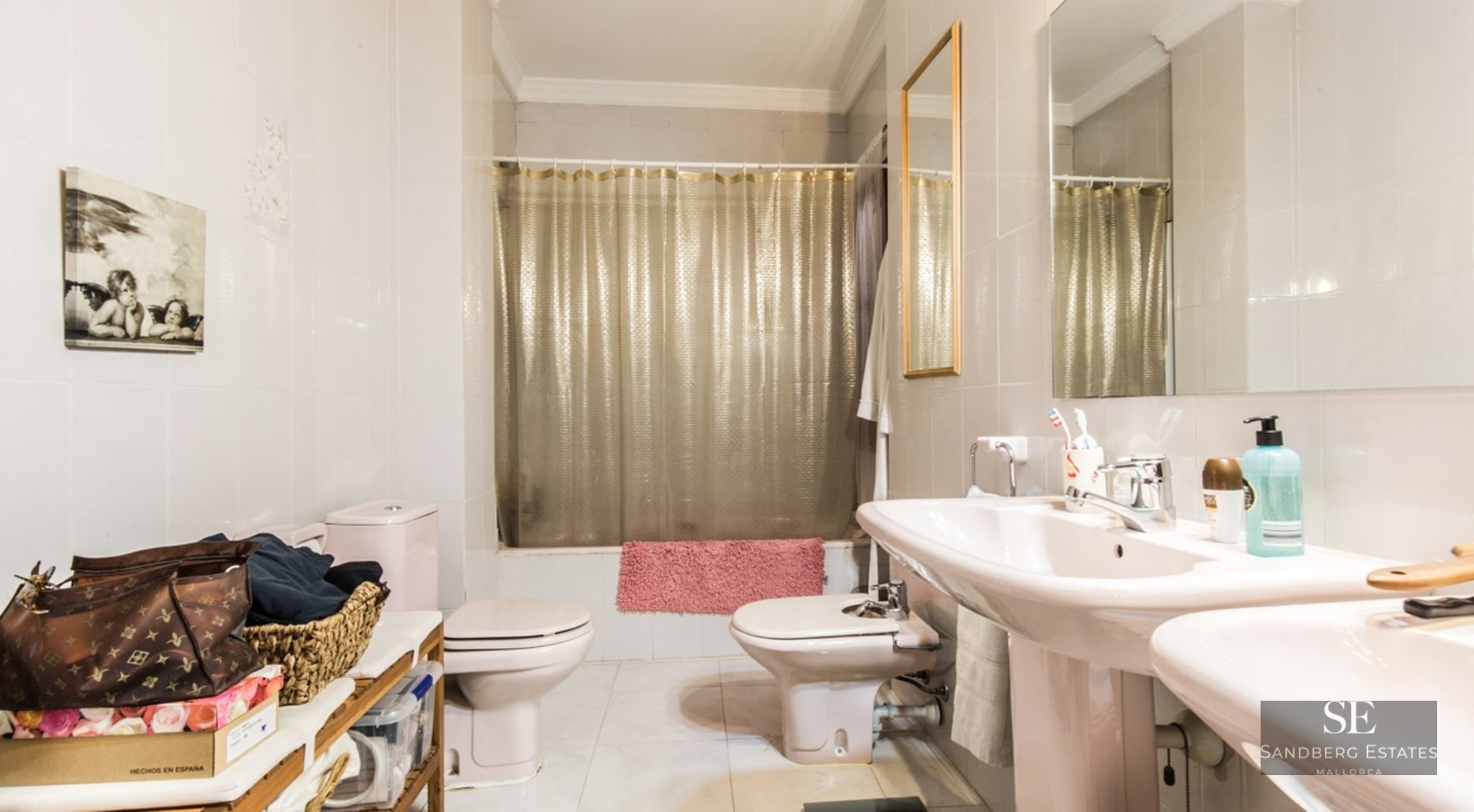 Bathroom with a double sink, toilet, bidet, and bathtub with a gold curtain.