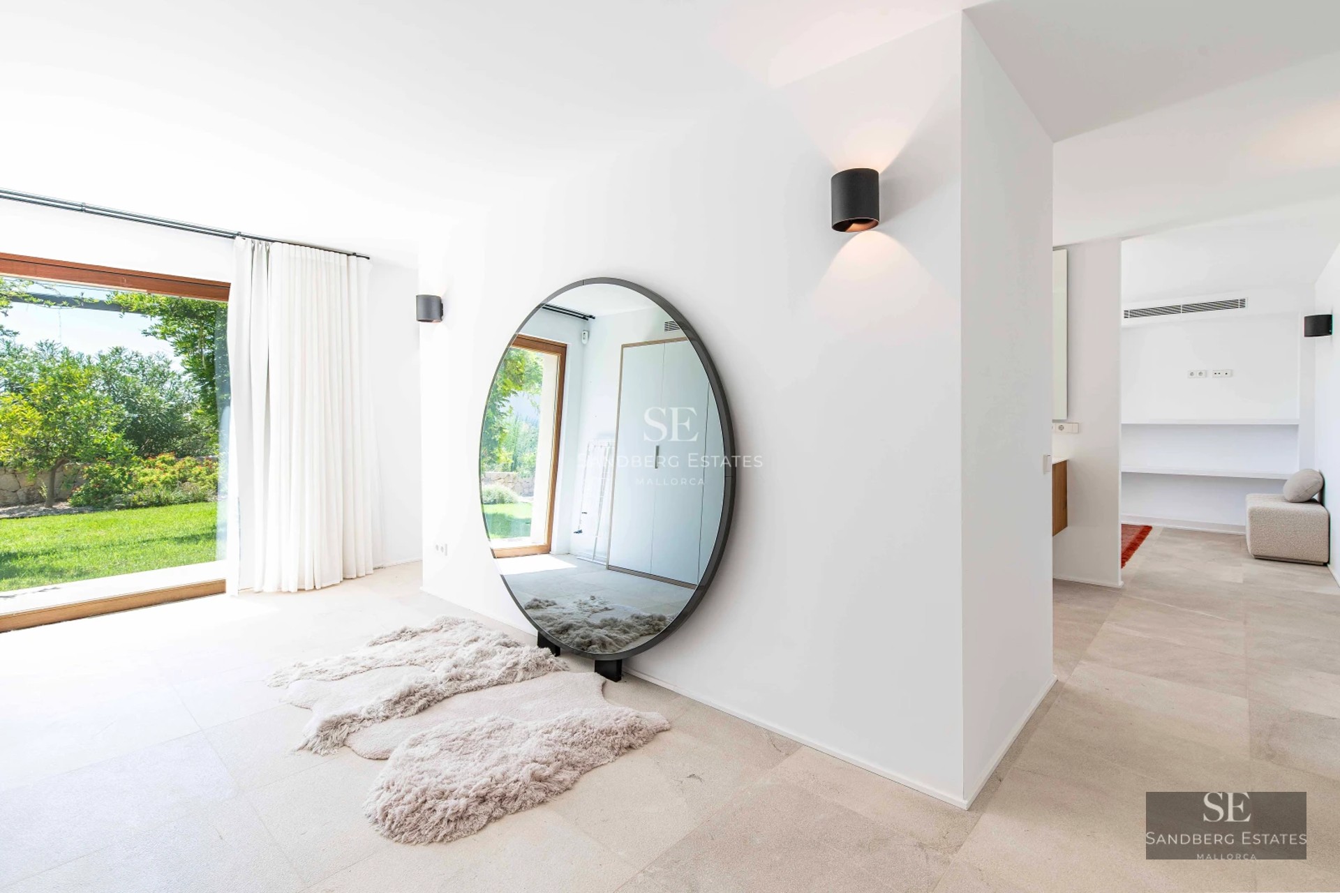 View of a modern infinity pool with lounge chairs and umbrellas, surrounded by lush greenery. Minimalist architecture.