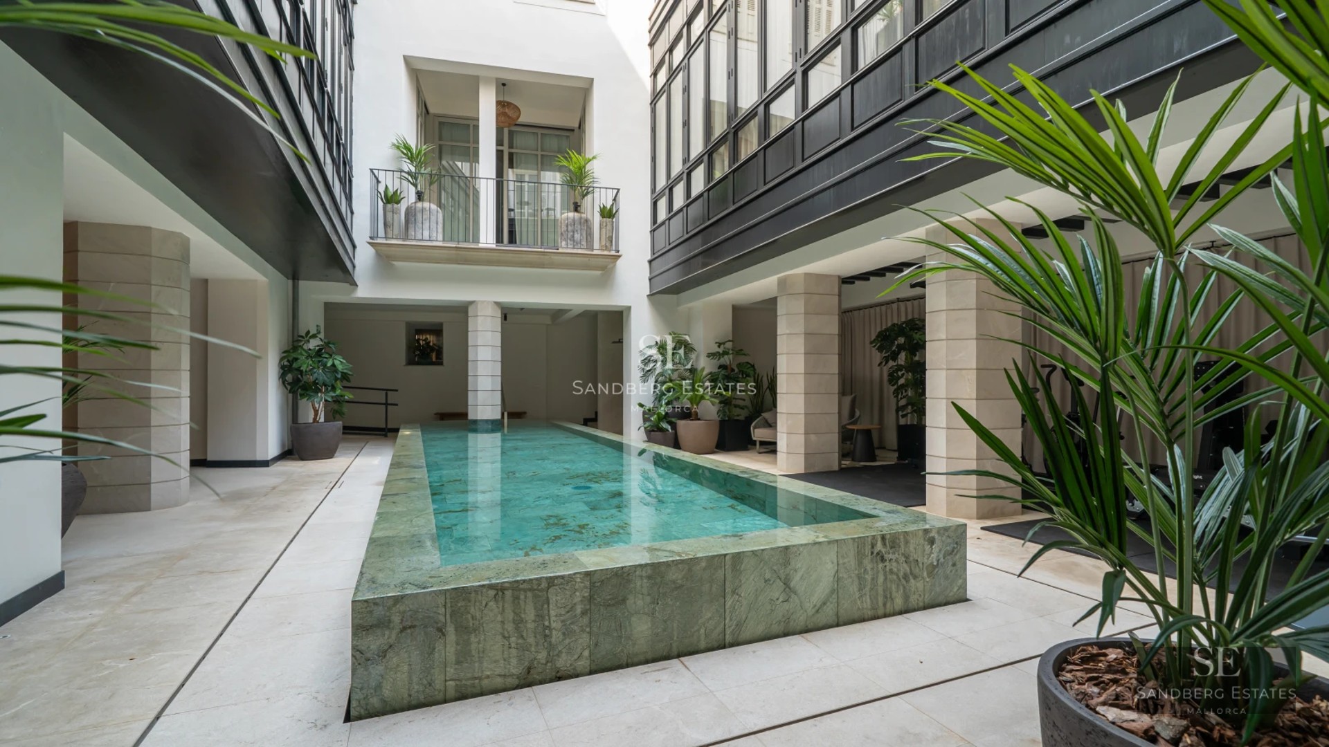 Exterior view of a modern villa featuring an infinity pool and expansive terraces overlooking the sea. Minimalist design and lush gardens.