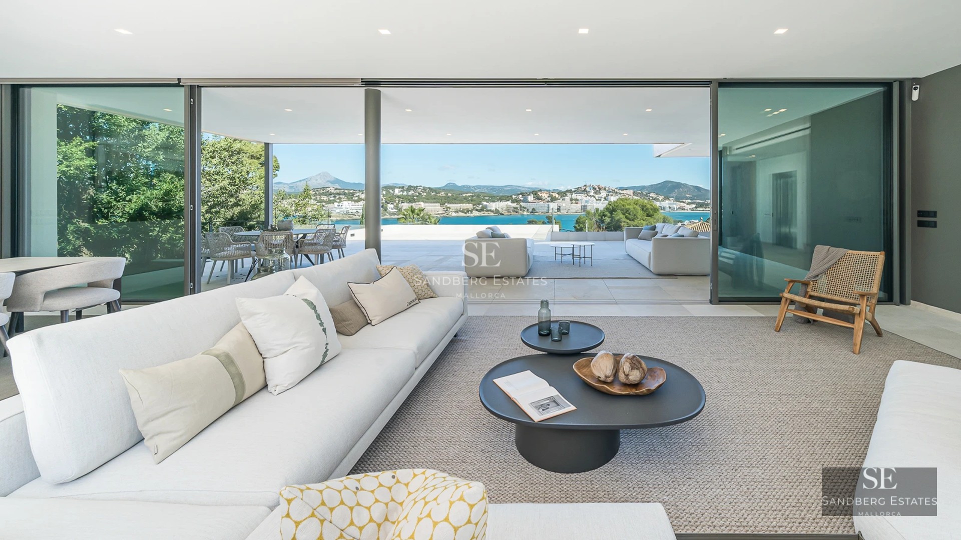 Exterior view of a modern villa with infinity pool, spacious terraces, and minimalist design. Ambient lighting and lush vegetation.