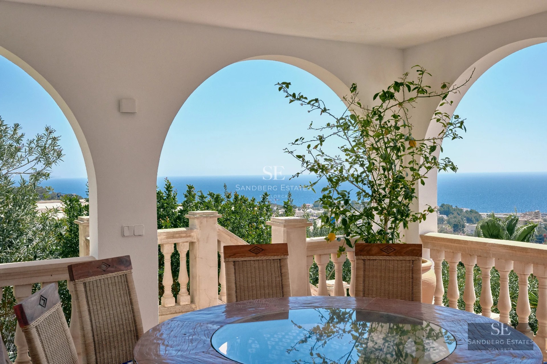 View of infinity pool surrounded by modern architecture with large windows and lush greenery. Contemporary and stylish design.