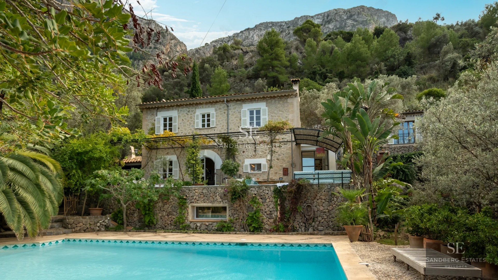 Exterior view of a modern villa with infinity pool, lush garden and minimalist architecture. Large windows and terraces.