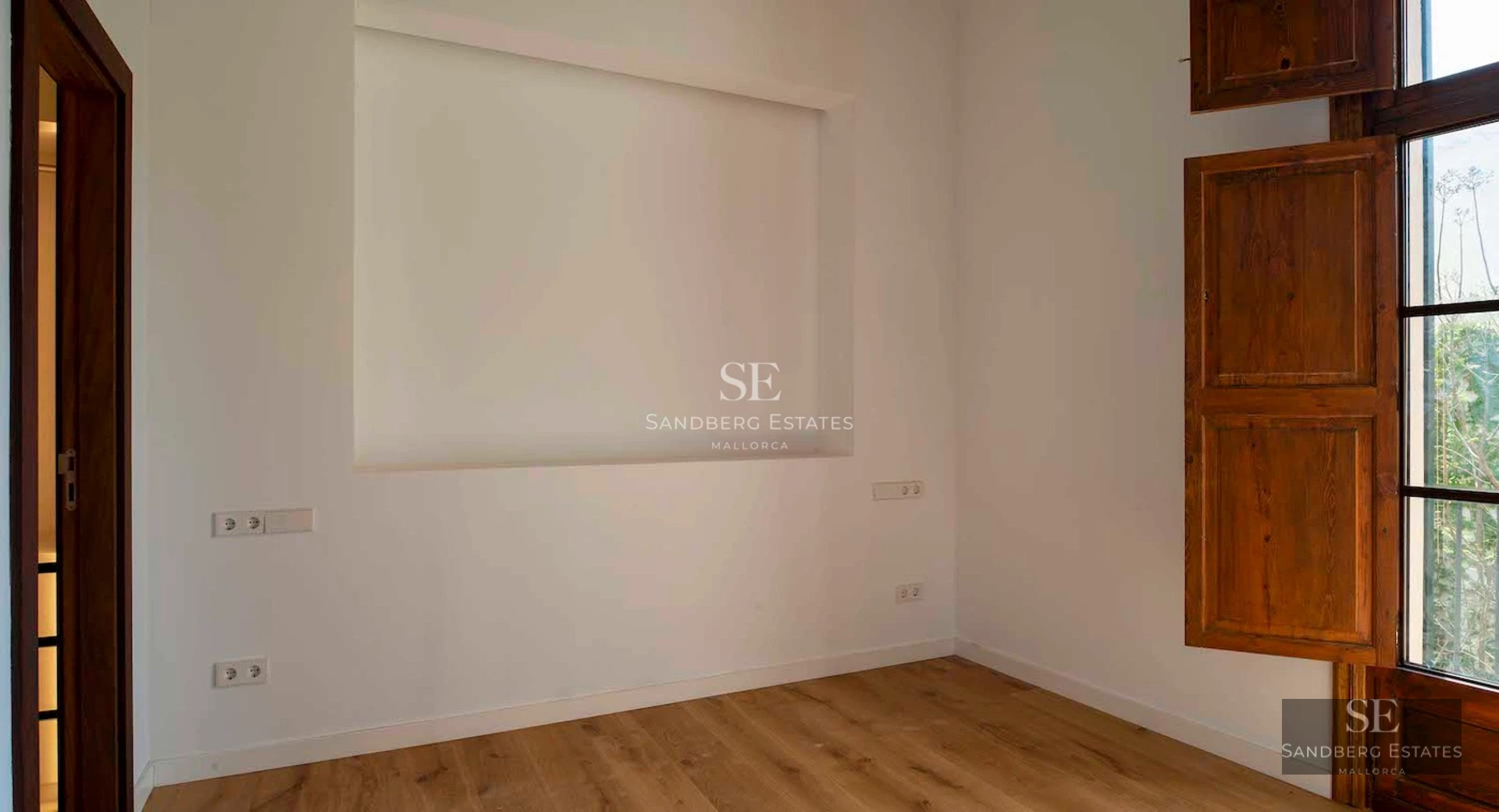 Spacious balcony with glass railings offering sea and city skyline views. Modern and elegant outdoor furniture.