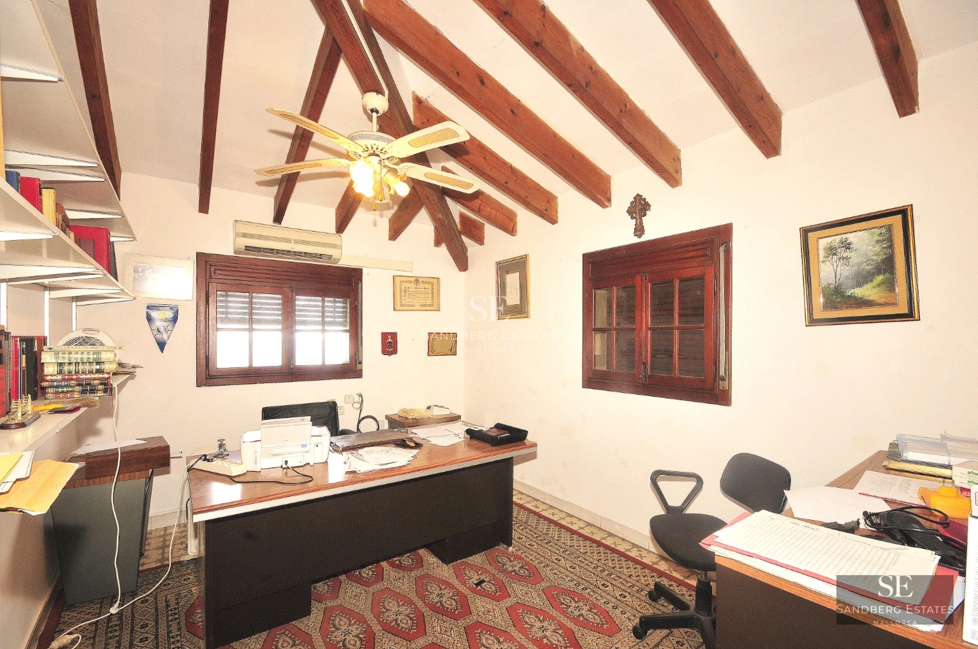 Spacious living room with window walls, beige sofas, fireplace and sea view. Elegant interior design with natural lighting.