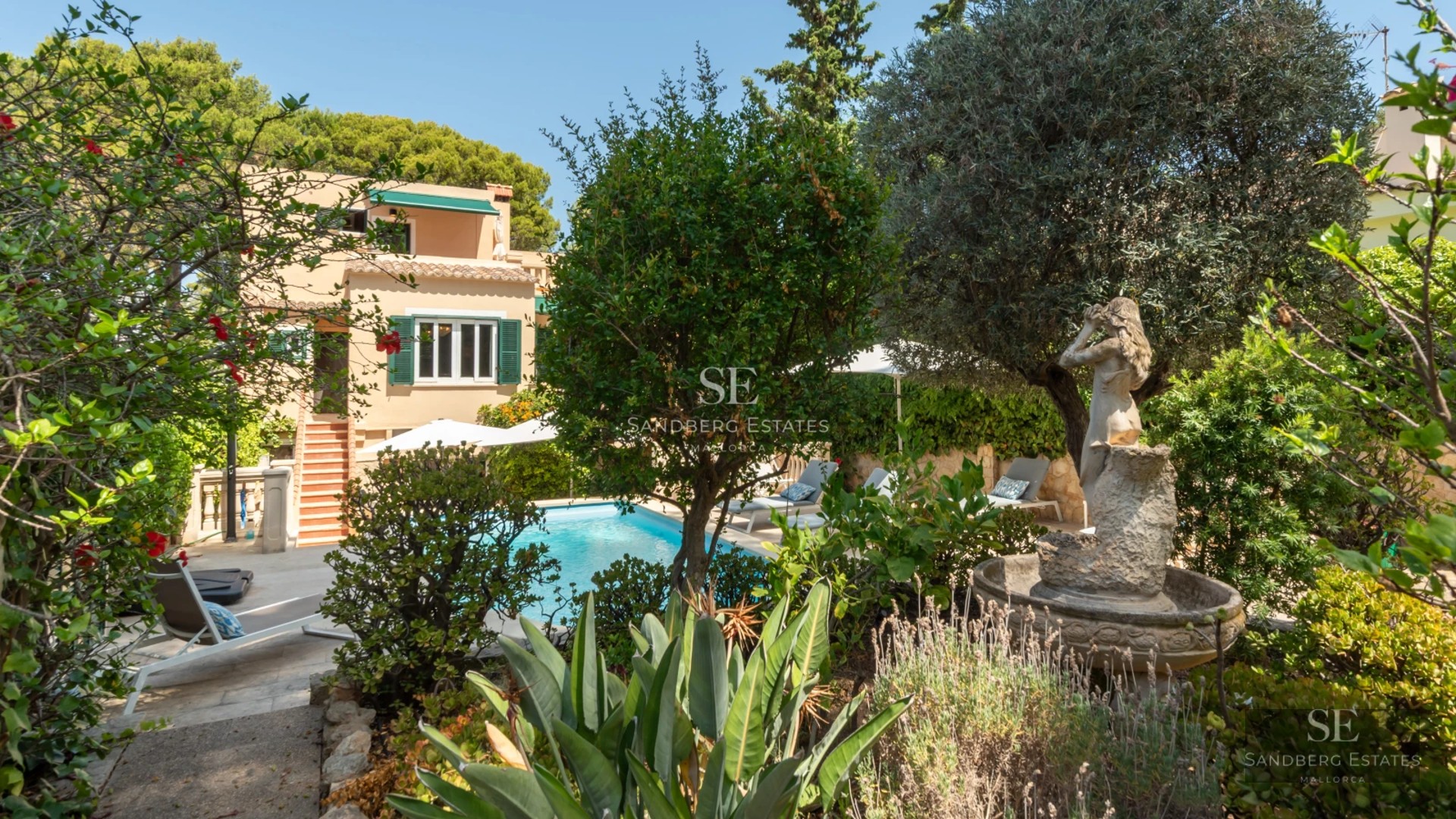 Exterior view of a modern villa featuring a pool, expansive terraces, large windows, and lush vegetation. Minimalist and elegant design.