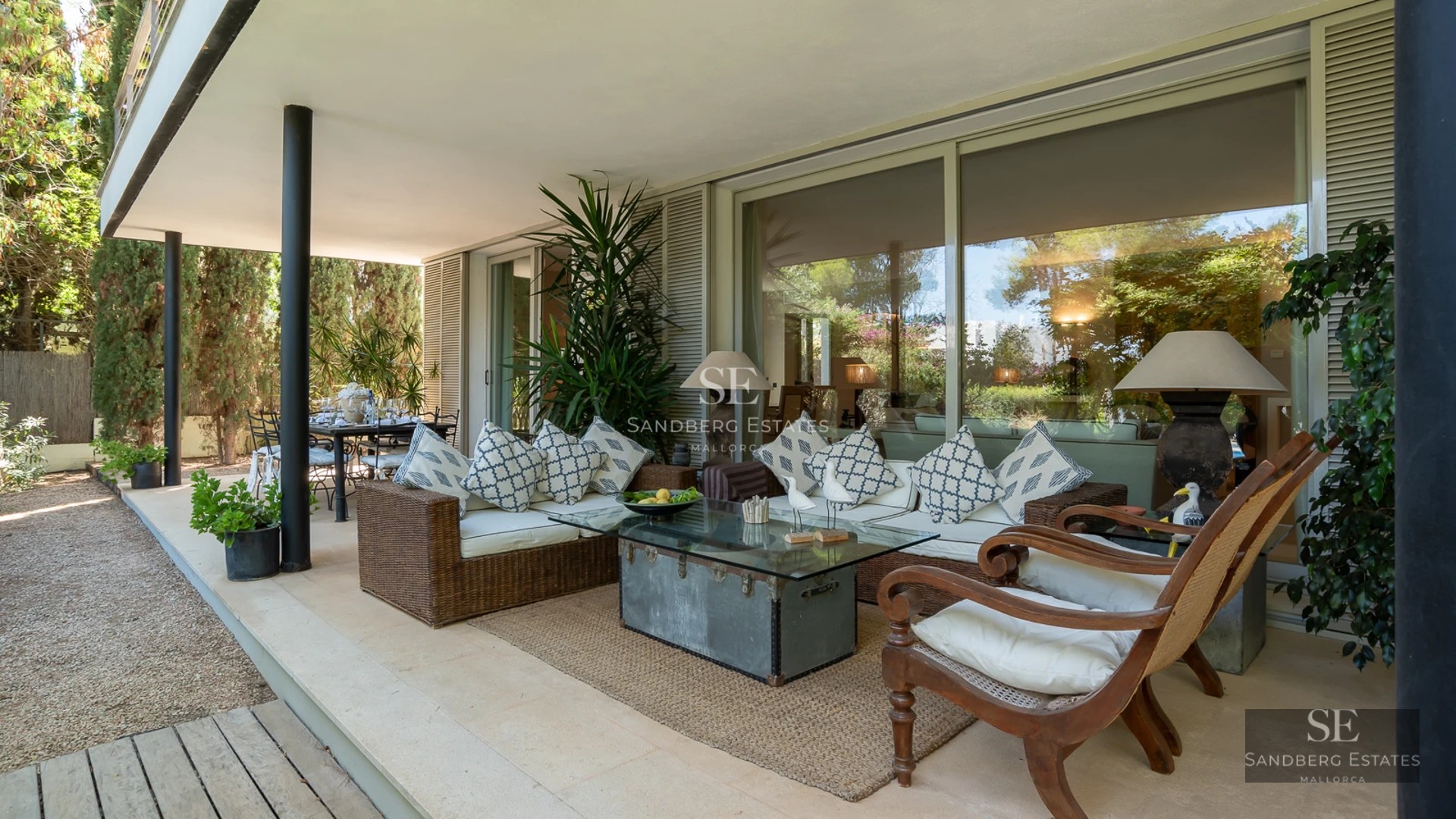 Spacious balcony with sea view. Modern outdoor furniture, glass railing and tiled floor. Luxurious and bright space.