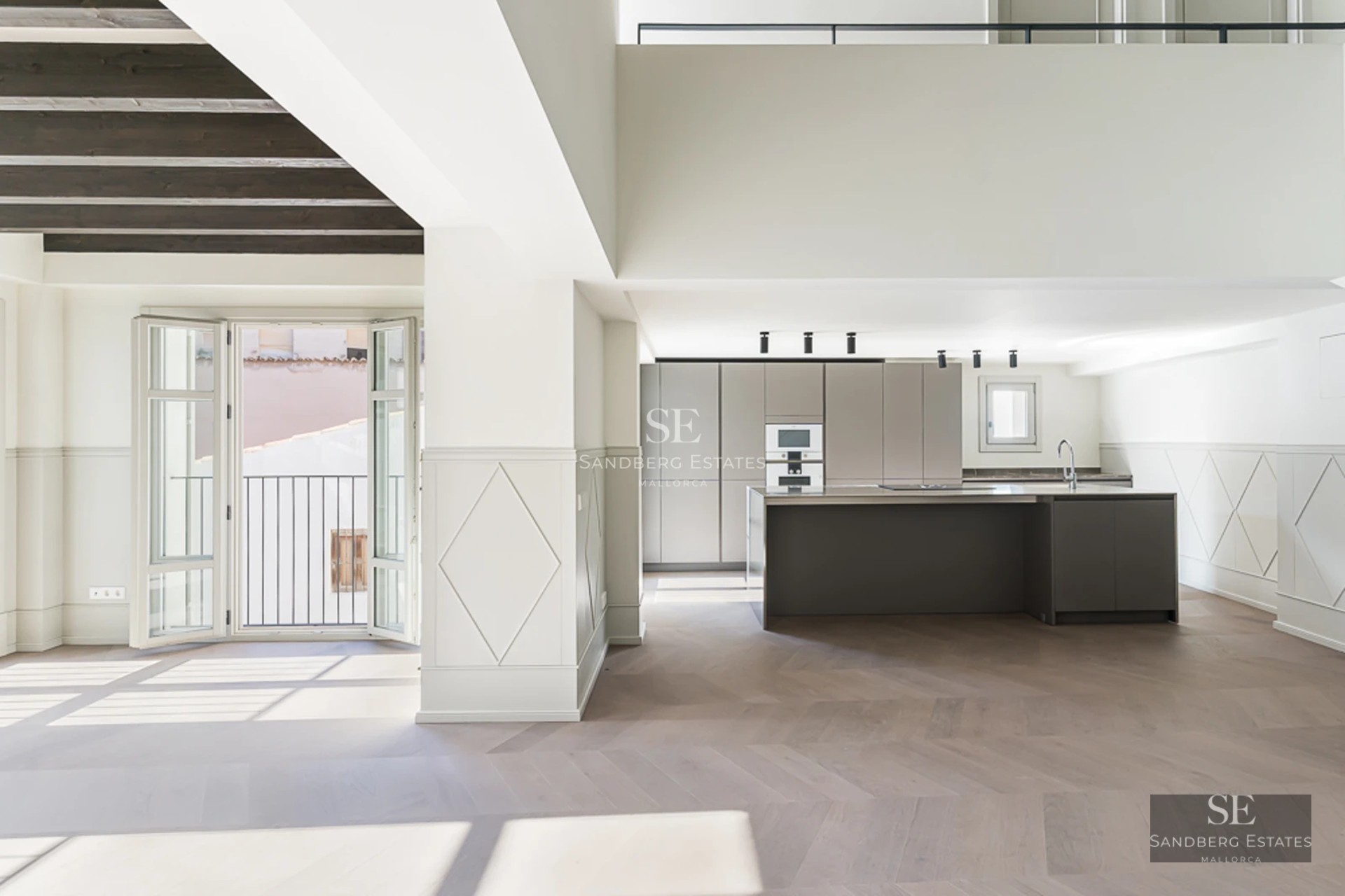 Spacious living room with picture windows, light wood floors, modern fireplace, and panoramic views. Minimalist furniture, abundant natural light.