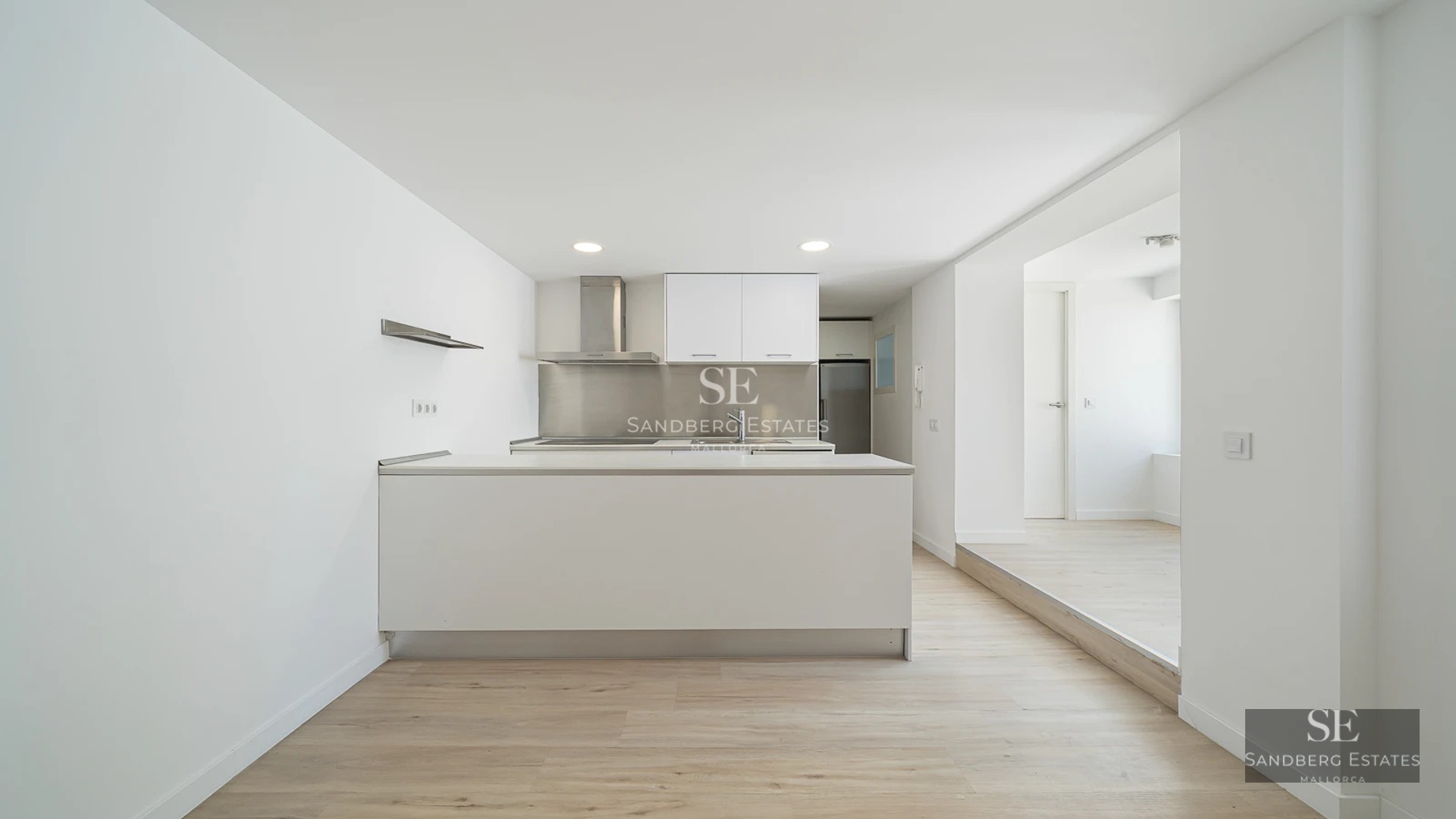 Wide view of modern living room with fireplace, balcony, and panoramic windows. Natural light, elegant design, neutral colors, and luxurious textures.
