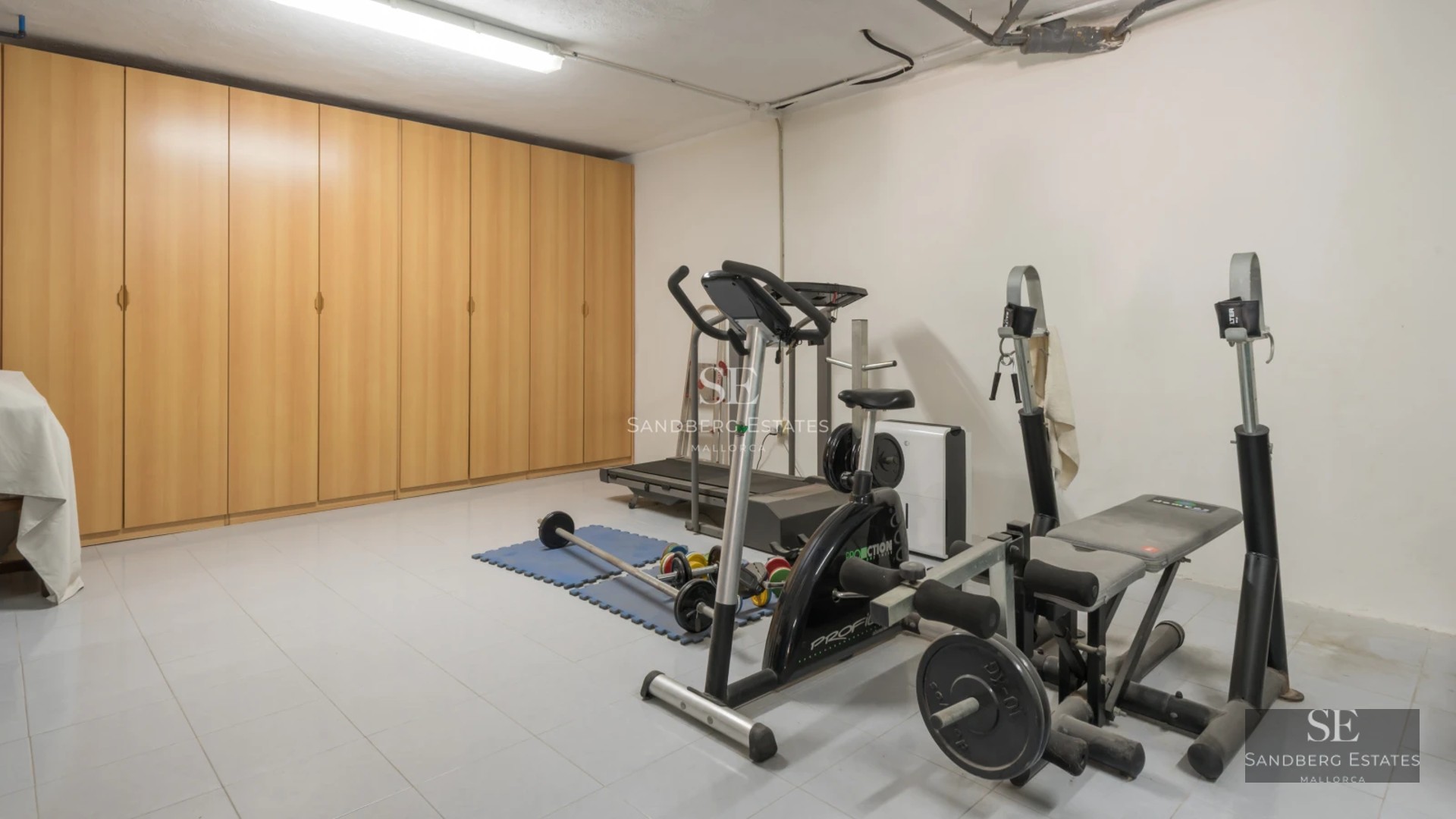 Exterior view of a modern villa featuring a pool, sun loungers, and a large garden. Contemporary architecture with expansive windows.