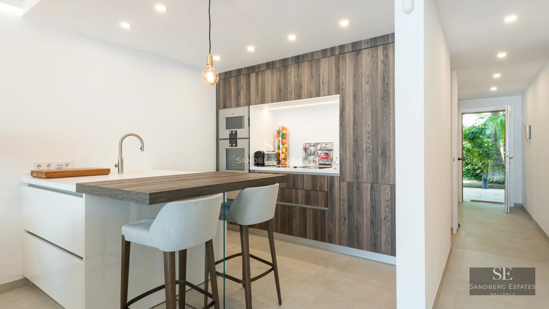 Exterior view of a modern house featuring a swimming pool, manicured garden, and large window illuminating the interior with natural light.