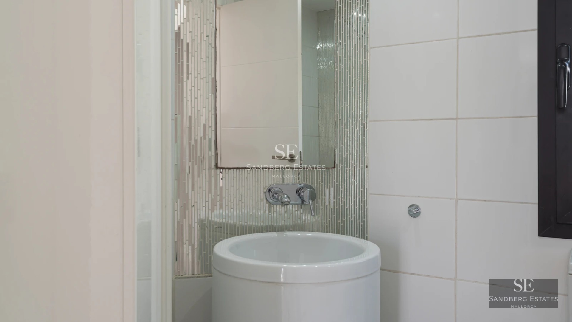 View of infinity pool with sun loungers, manicured garden, and modern architecture. Luxury and comfort in a tranquil setting.