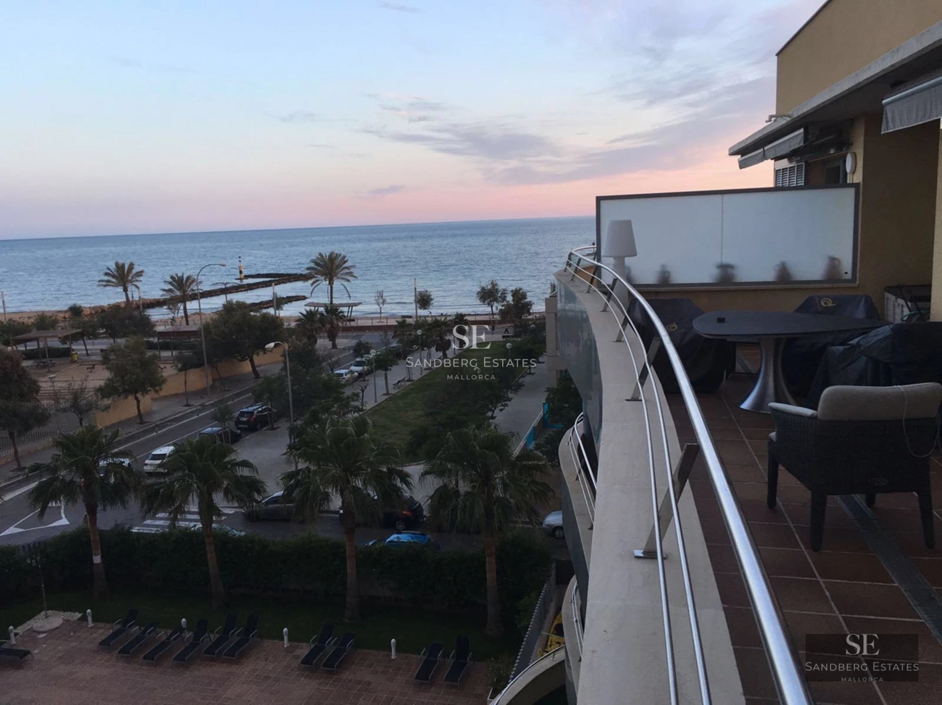 Grand balcon avec vue panoramique sur la mer. Design moderne avec garde-corps en verre. Soleil et détente dans un cadre unique.