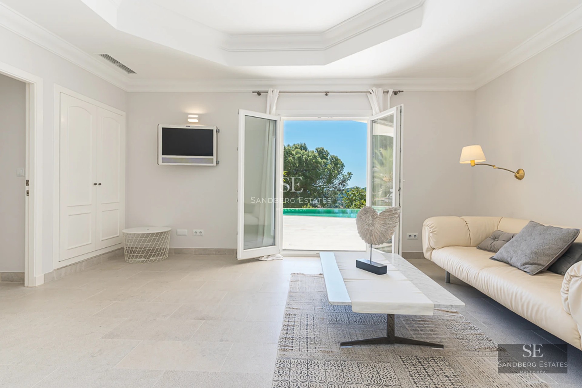 Bright living room with panoramic windows, grey sofas, wooden coffee table, and parquet flooring. Exterior view.