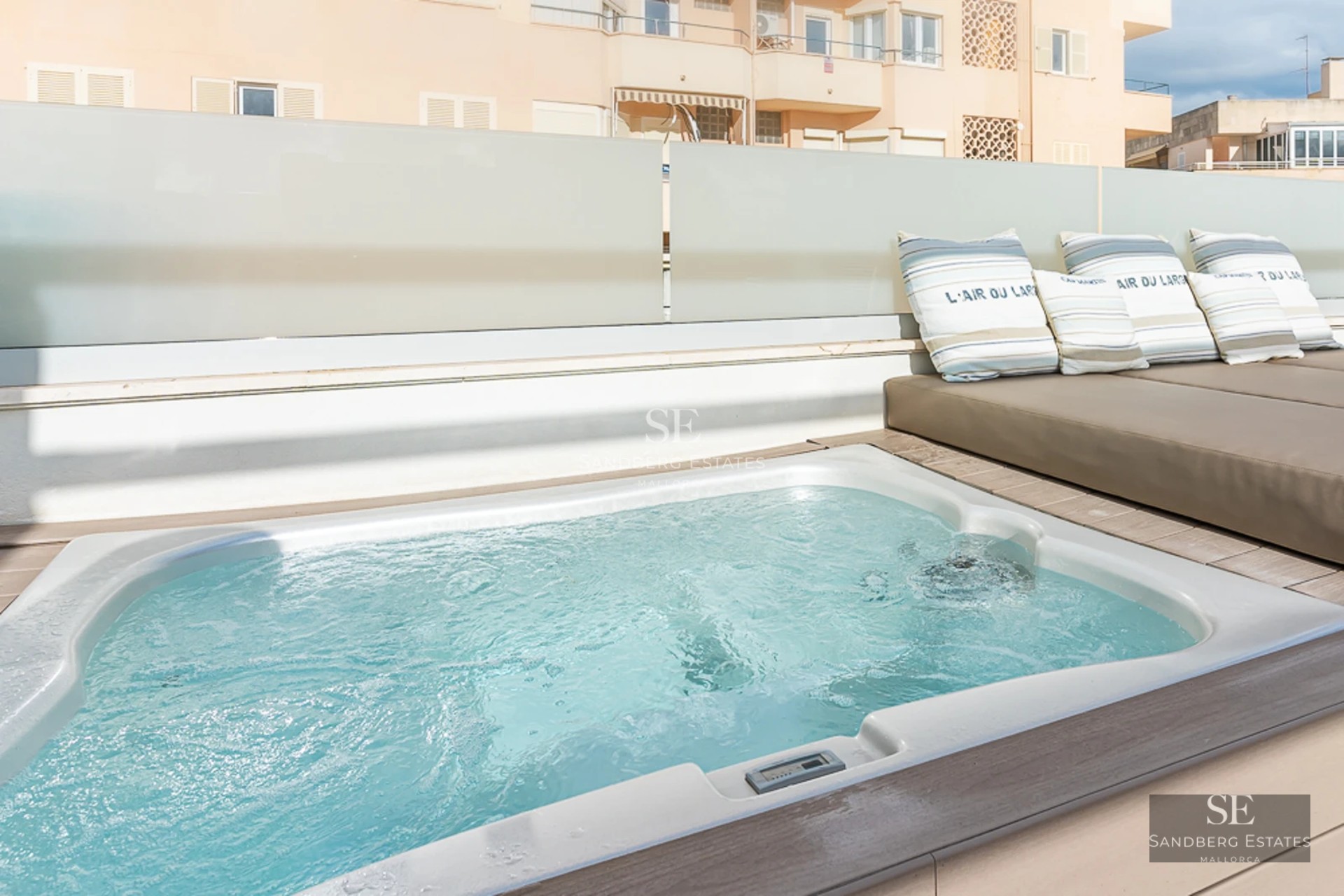 Spacious bright living room with panoramic windows, light wood floors, designer sofas and access to a terrace with panoramic views.