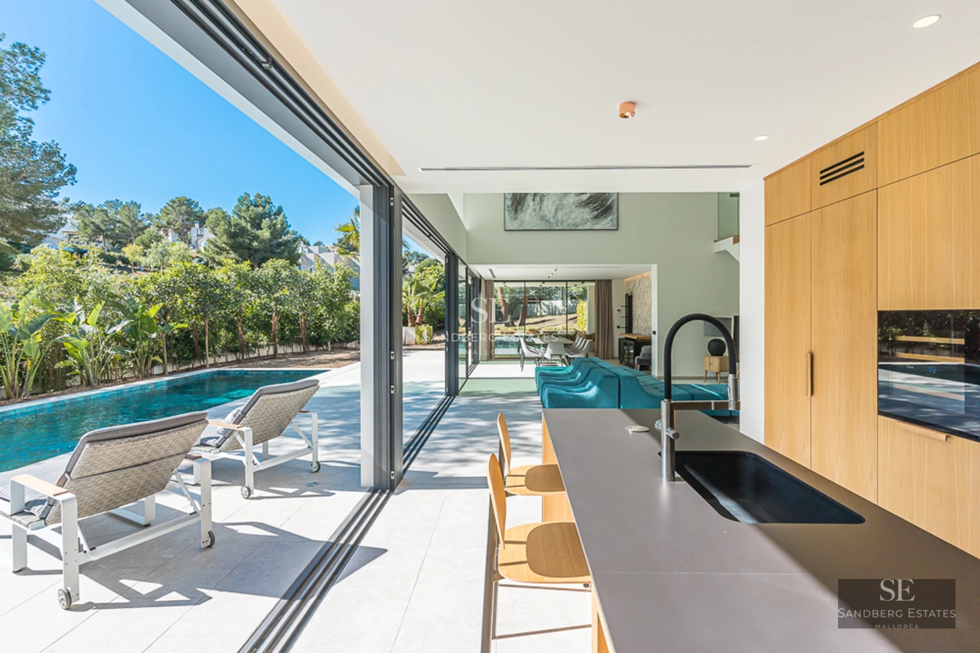 Vue d'une villa moderne avec piscine à débordement, transats et jardin paysager. Design minimaliste avec de grandes baies vitrées et une lumière naturelle abondante.