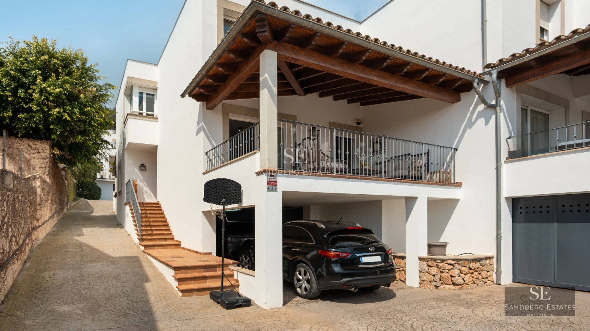Aerial view of a modern villa with a pool, lush garden, and minimalist architectural design featuring large windows.
