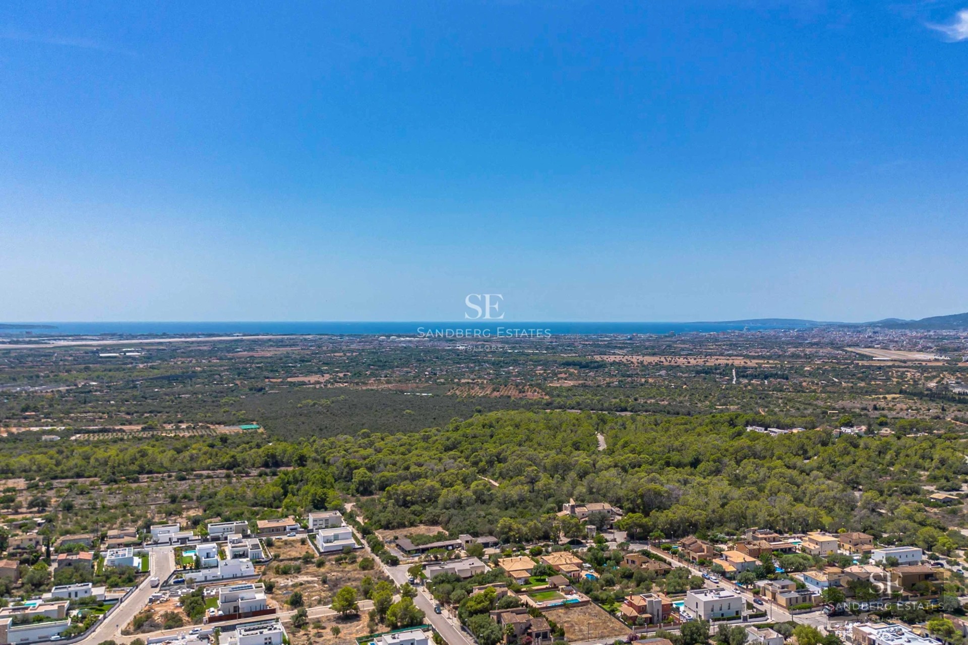 Spacious living room with large windows, sea view, light wood floors, and modern furniture in neutral tones.