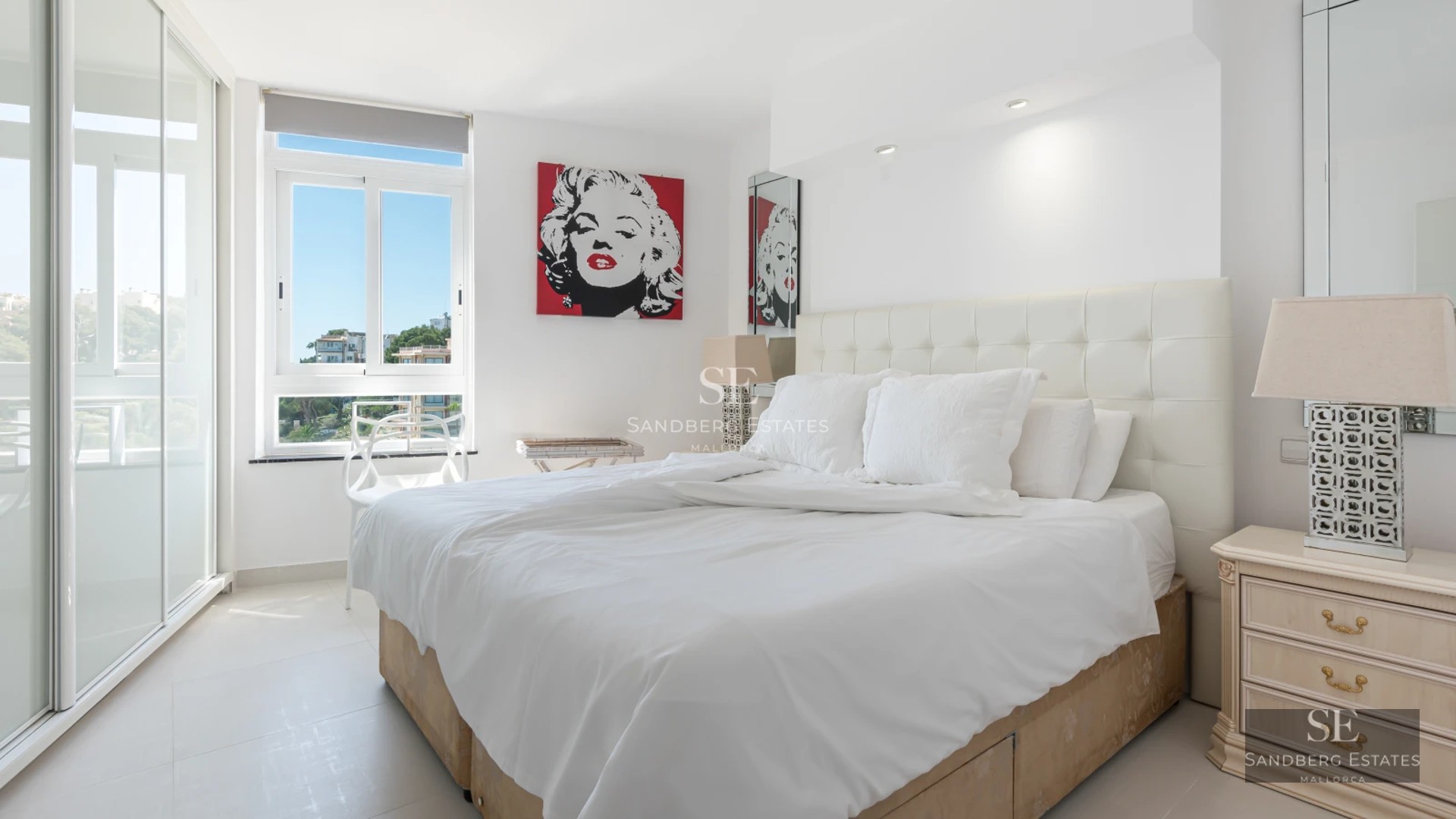 Expansive infinity pool surrounded by green lawn and modern architecture featuring large windows and a wooden facade.