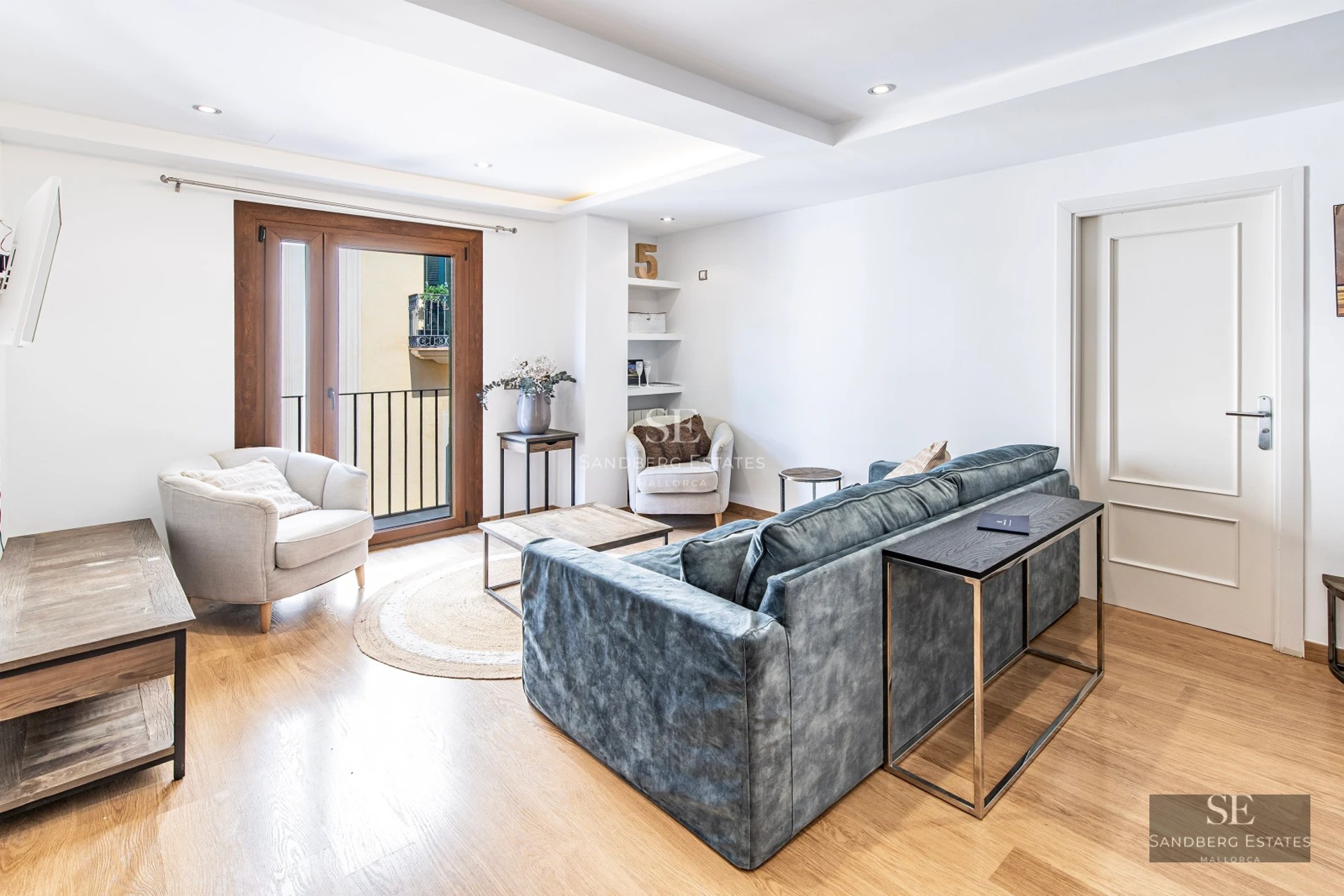 View of a modern pool with elegant furniture, surrounded by gardens and a minimalist house with large windows.