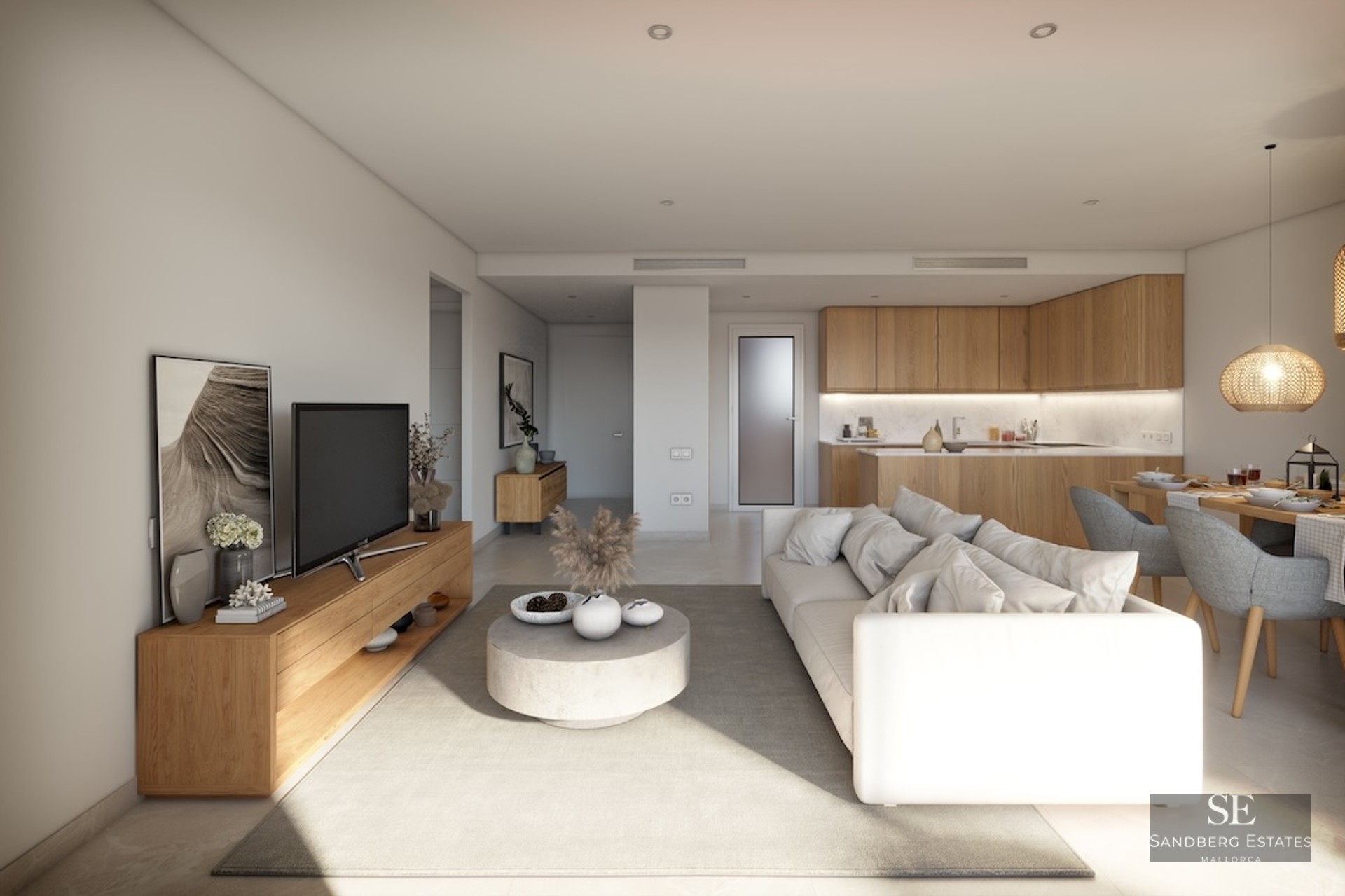 Bright modern living room with a white sofa, wooden furniture, and an integrated kitchen in the background.