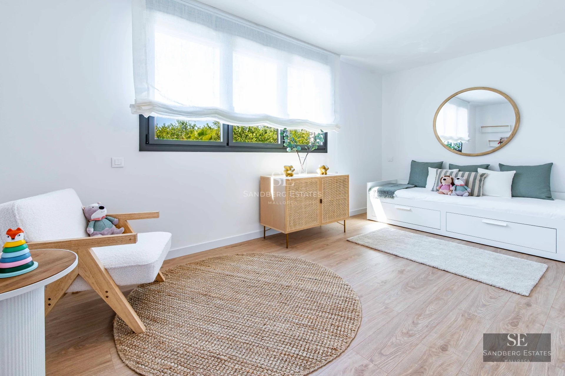 Living room view with floor-to-ceiling windows overlooking the sea. Modern design, natural light, and neutral tones. Beige sofa, rug, and minimalist decor.