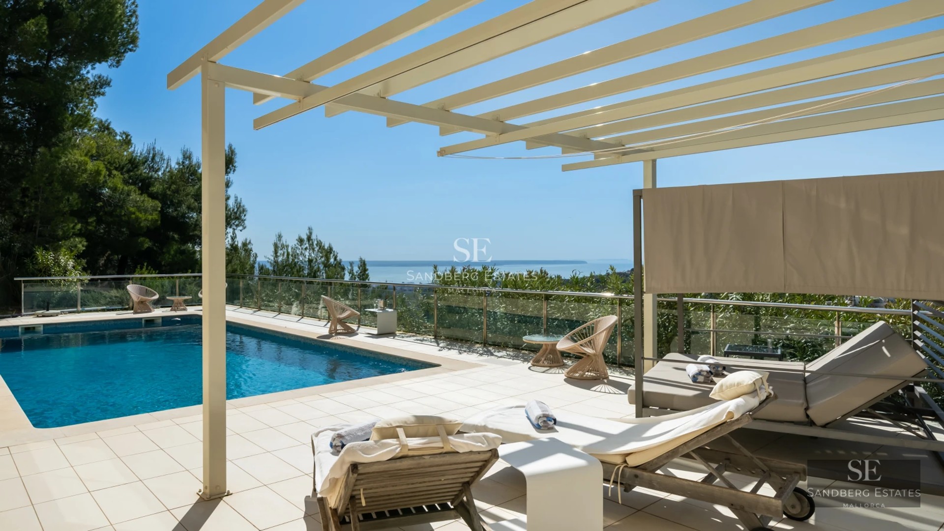 Spacious living room with large windows overlooking the pool. Modern sofas, warm lighting, and minimalist design.
