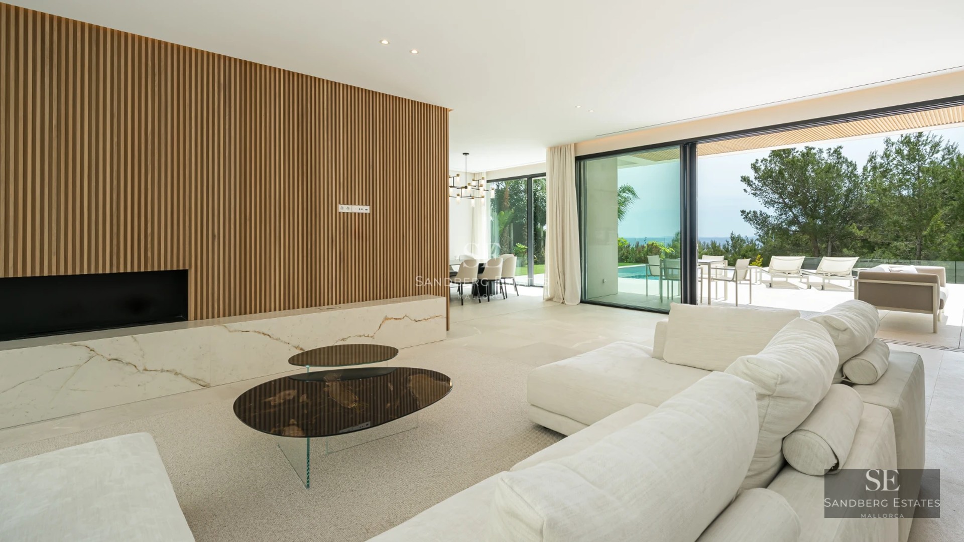 Spacious living room with large windows offering panoramic sea views. Modern design, abundant natural light, neutral color palette.