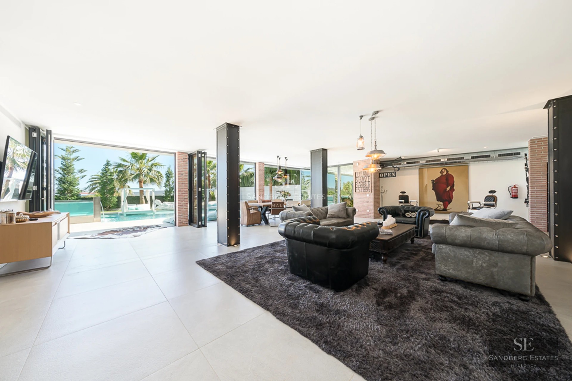 Aerial view of modern villa featuring a bright blue pool, lush garden, and minimalist architecture. Expansive terraces and abundant natural light.