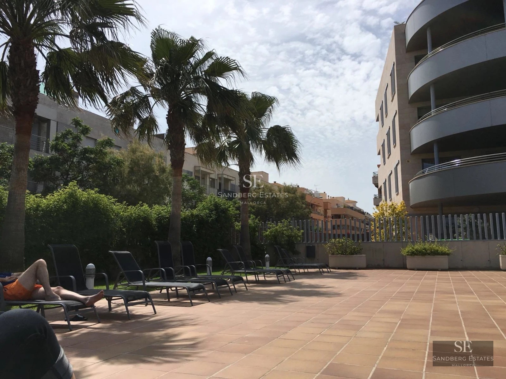 Salon lumineux avec de grandes baies vitrées, canapé beige, parquet clair et vue panoramique sur la mer. Design moderne et élégant.