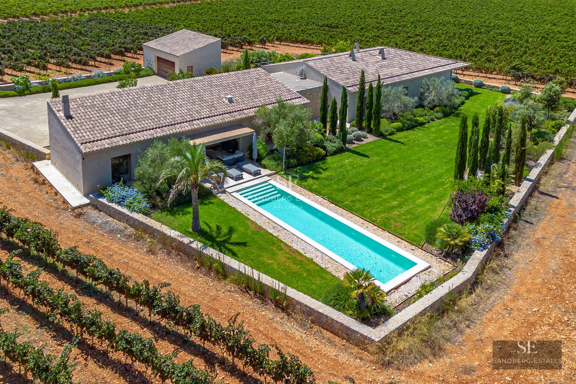 Exterior view of a modern villa featuring a pool, garden, and large windows. Minimalist architecture with natural textures.