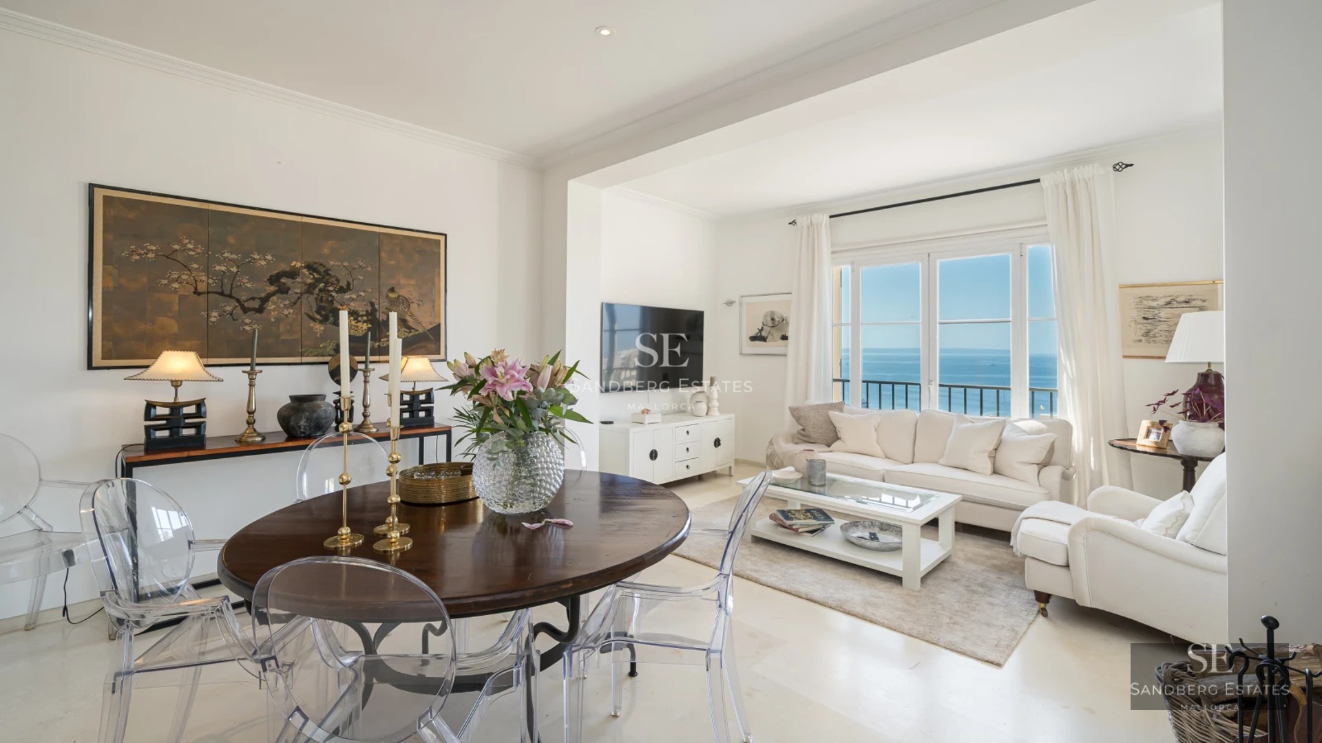 Spacious living room with sea views, balcony, and modern design. Light wood floors, gray sofas, and design details.