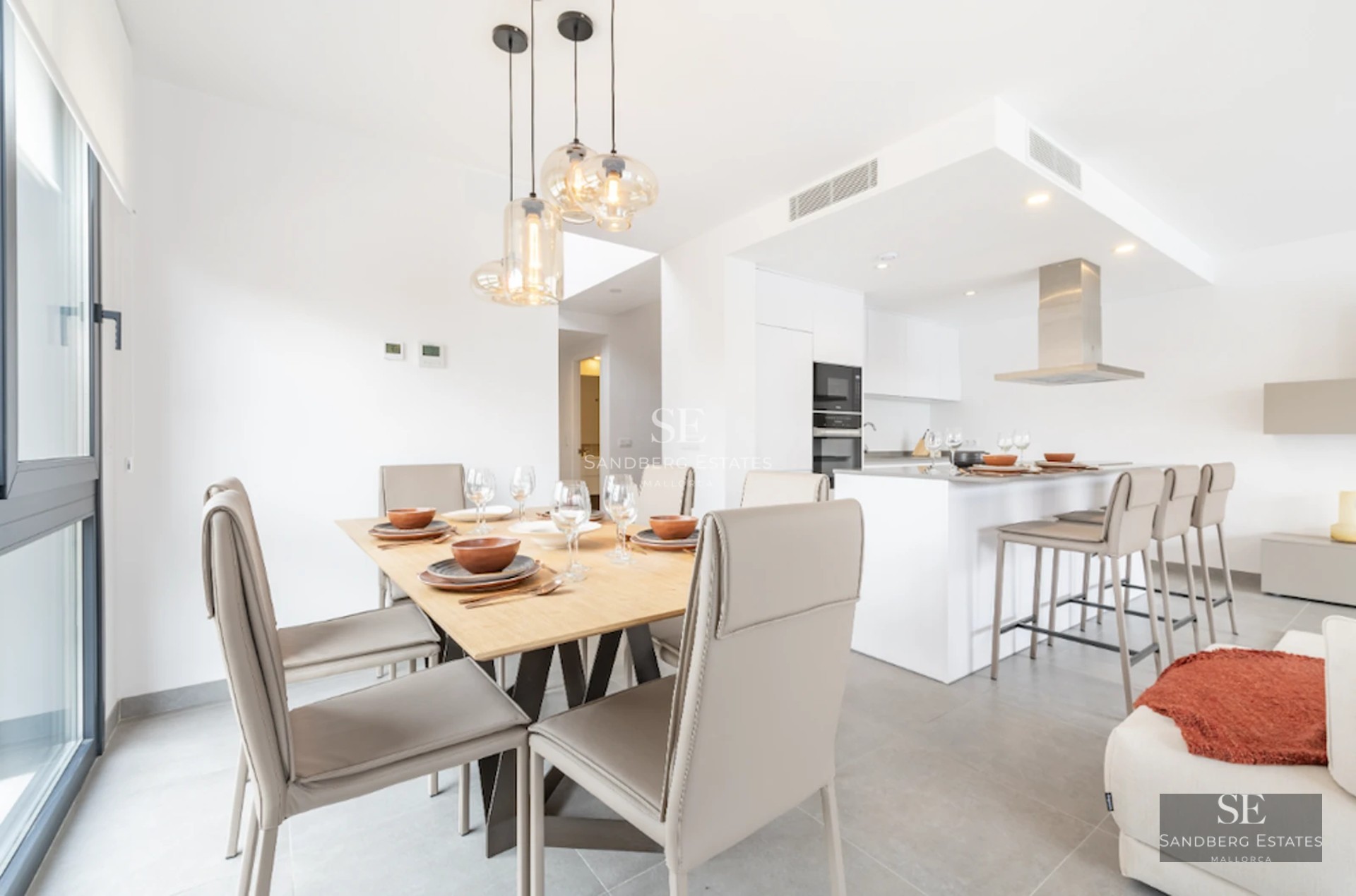 Spacious balcony with glass railing, panoramic sea view. Light floors and modern furniture.