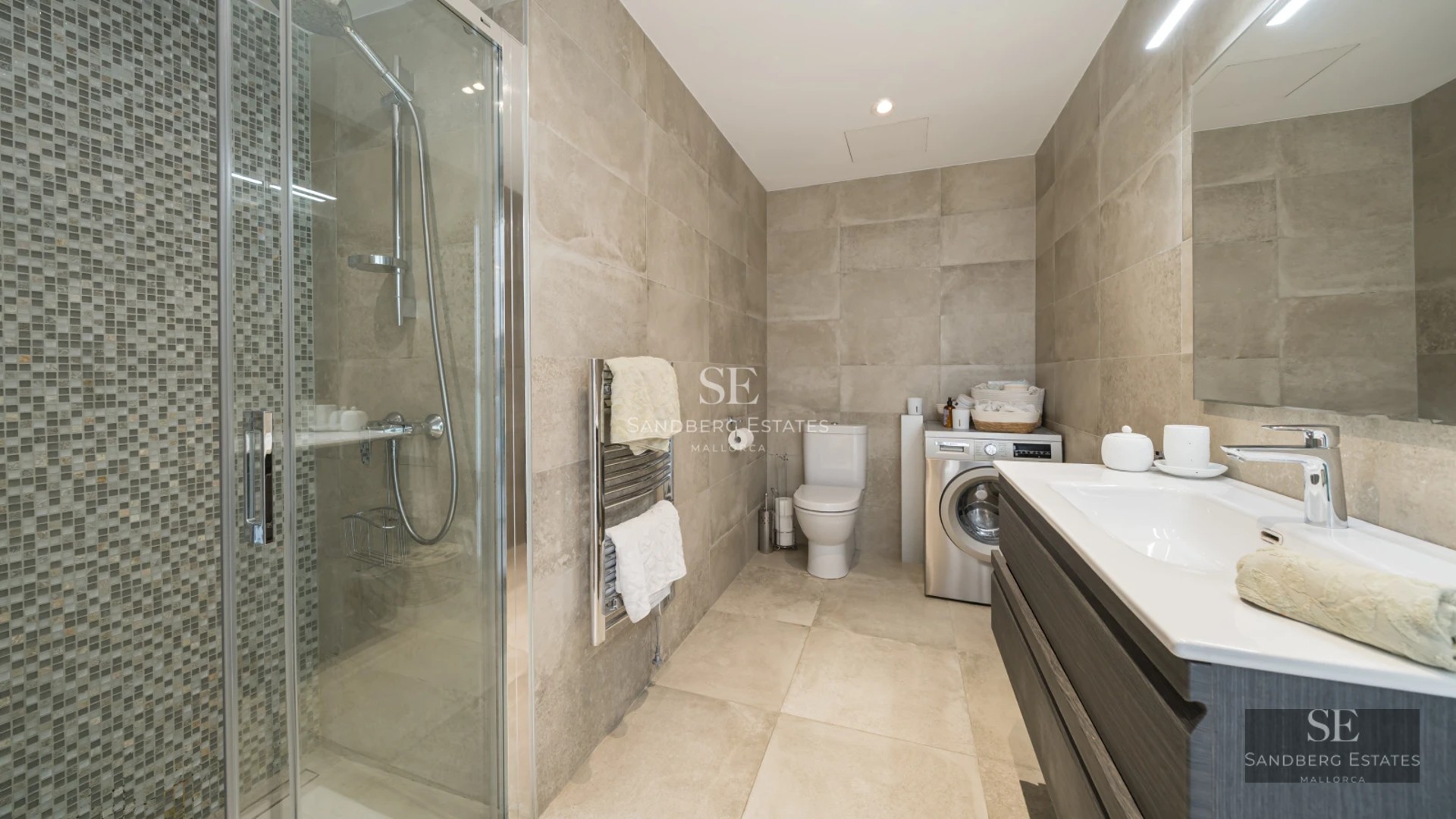 Spacious living room with panoramic sea views, light wood floors, natural lighting, and modern furniture in neutral tones.