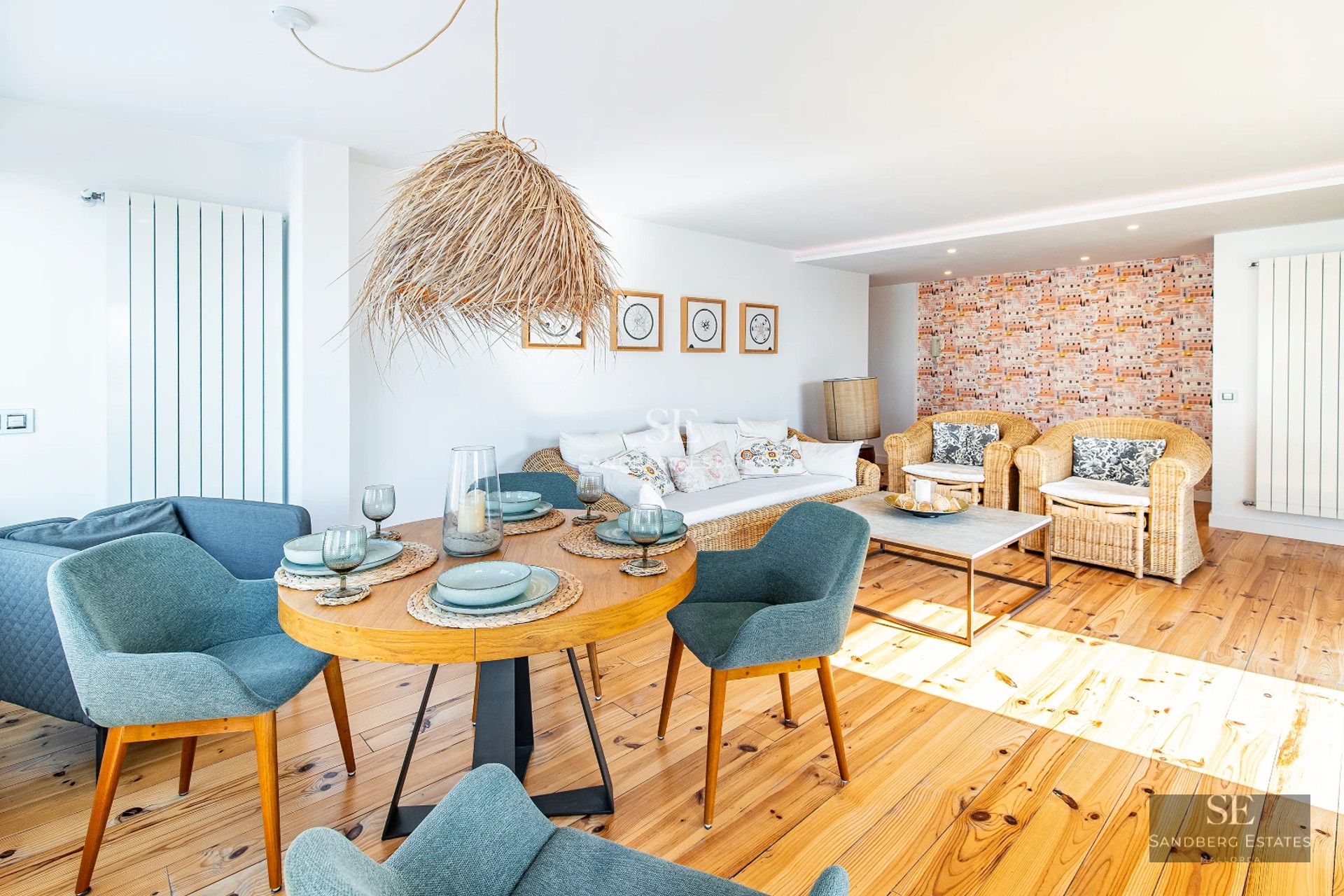 Spacious living room with large windows, light wood floor, modern sofa, and stunning city views. Natural lighting.