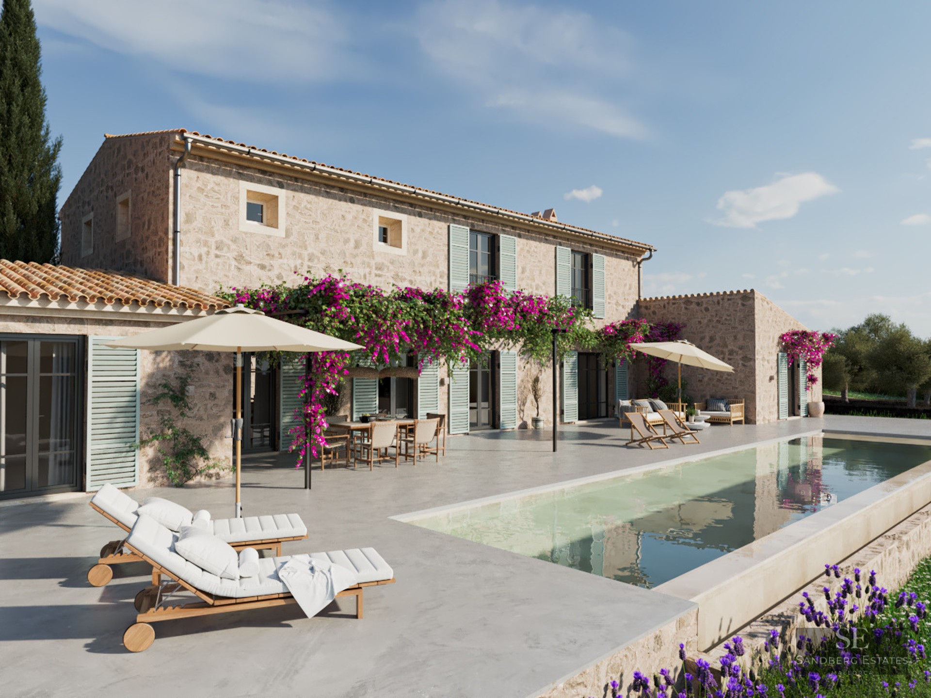 Large swimming pool next to a traditional stone villa with purple bougainvillea flowers and white sun loungers.