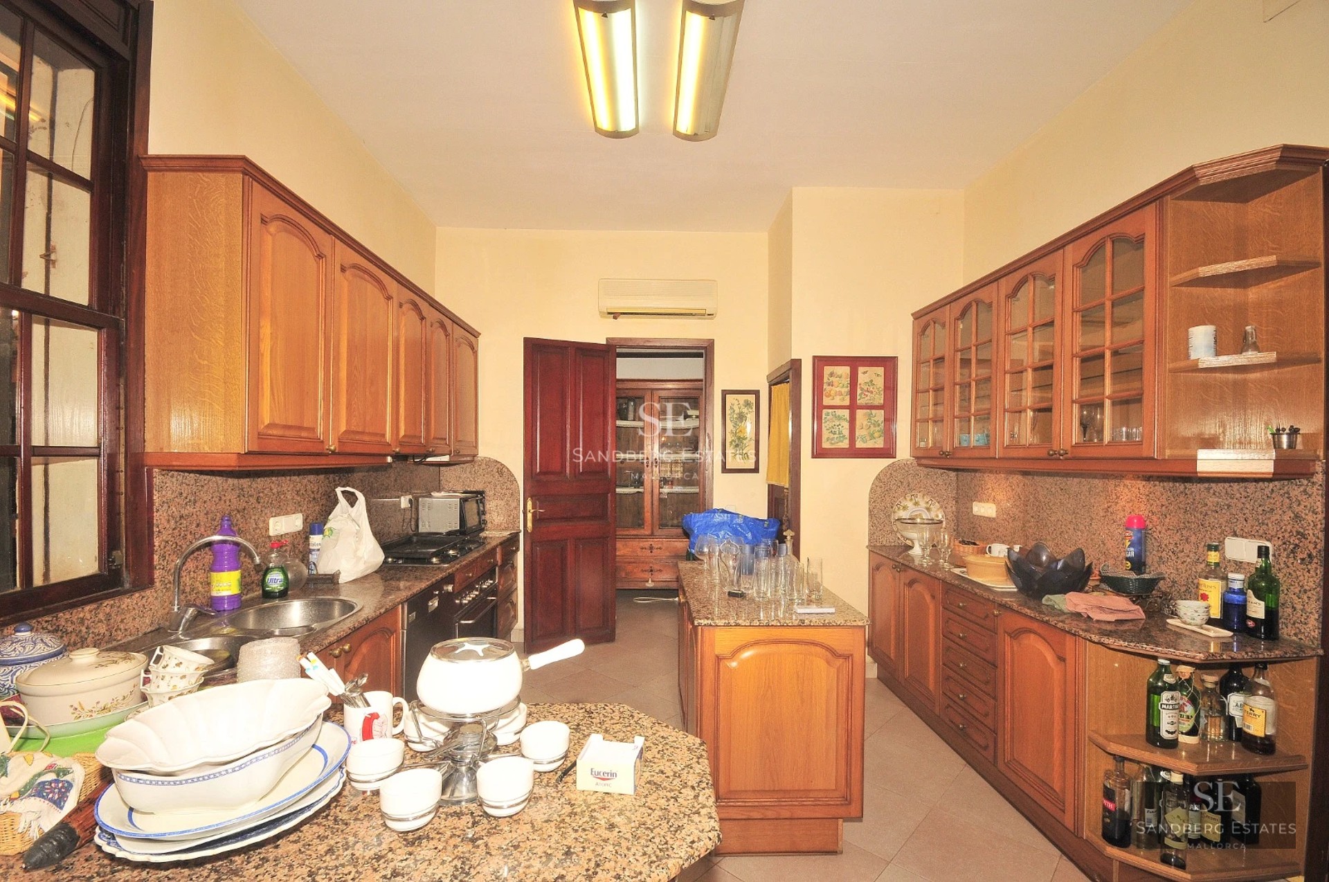 Spacious living room with sea view through panoramic windows. Modern design, light wood floors, white sofas and minimalist decor. Abundant natural light.