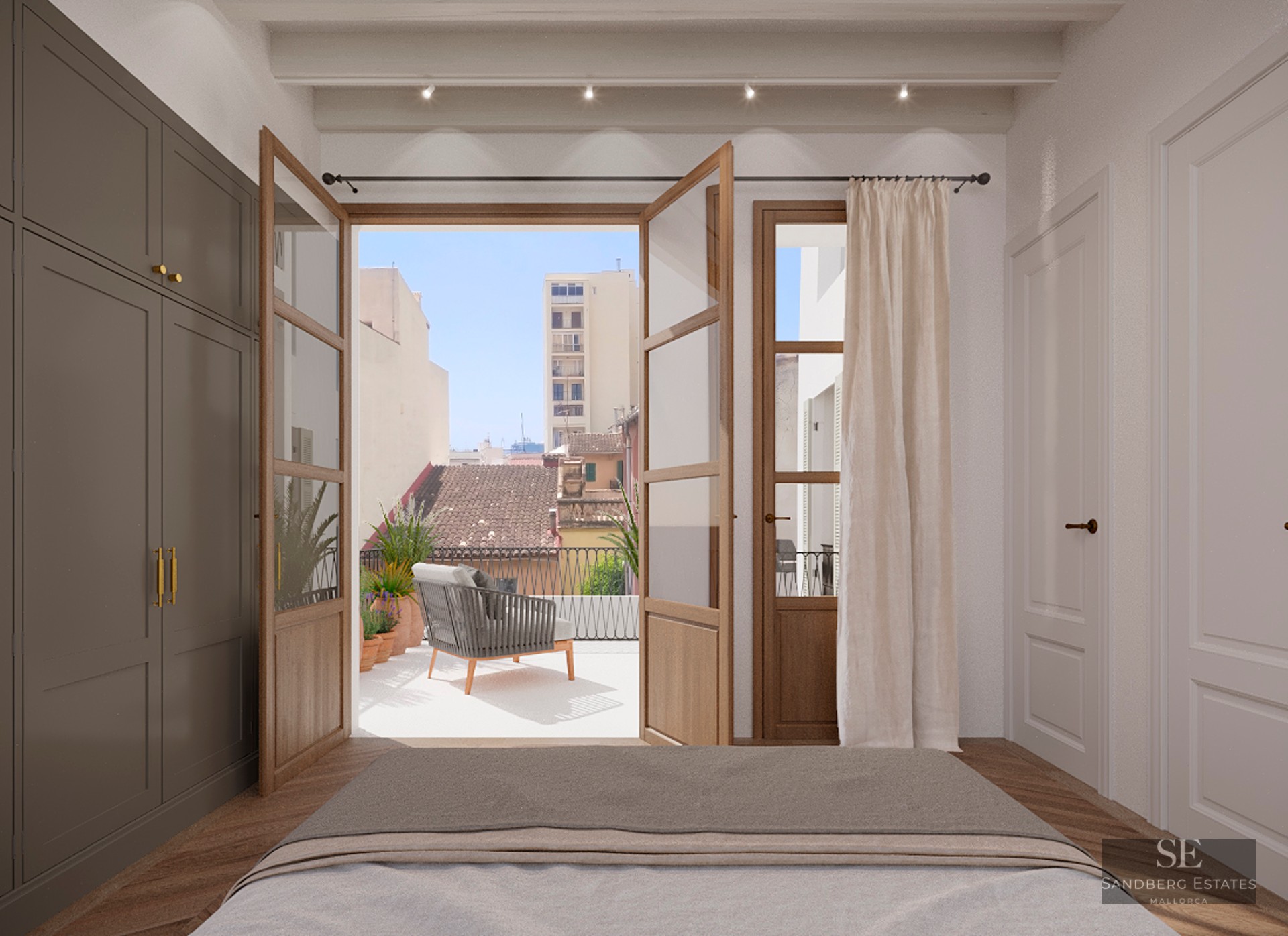 Modern bedroom view through open wooden doors to a sunny terrace with city views and outdoor seating.