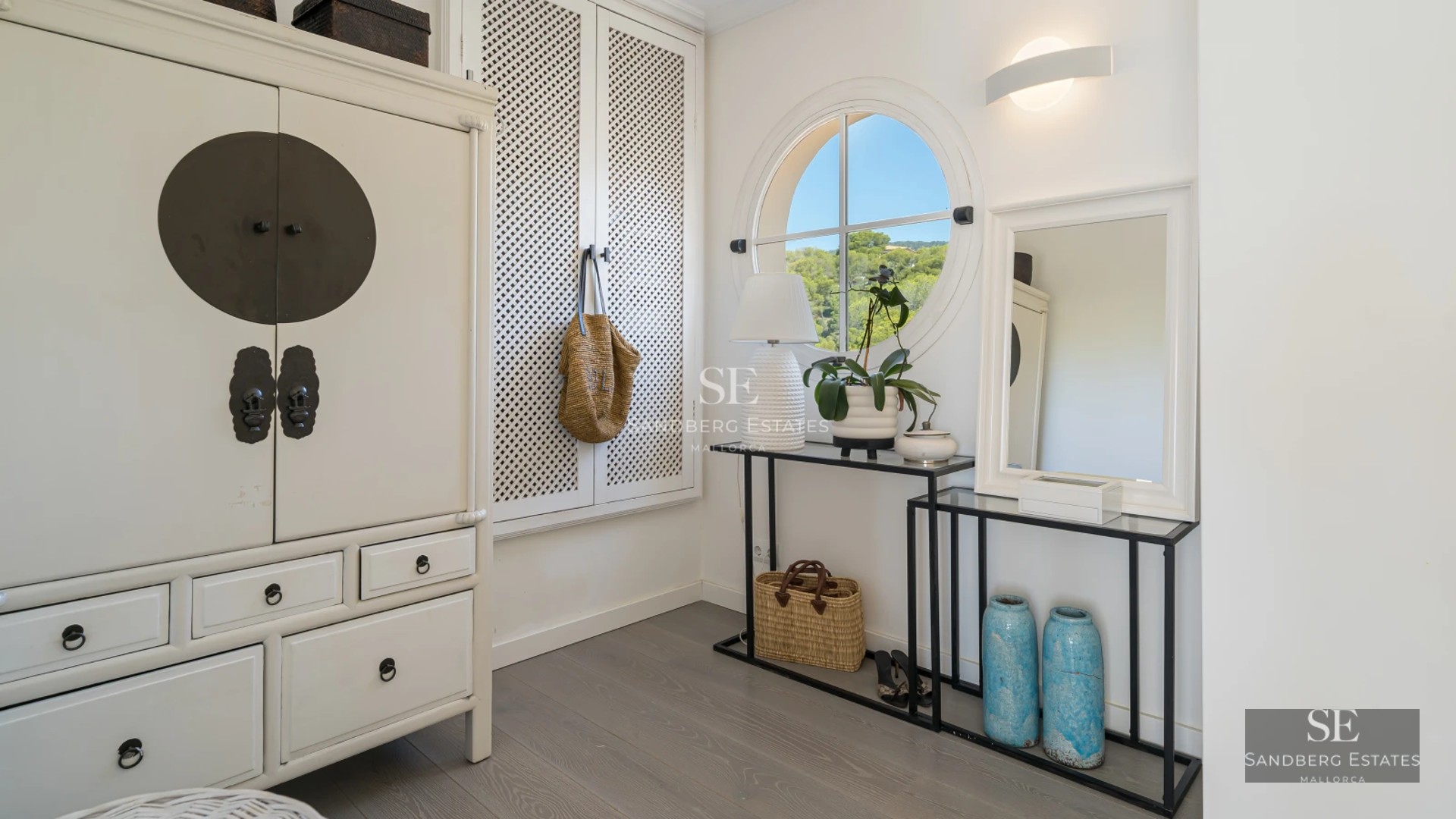Spacious living room featuring floor-to-ceiling windows, modern fireplace, beige sofas, light rug and panoramic views. Minimalist and elegant design.