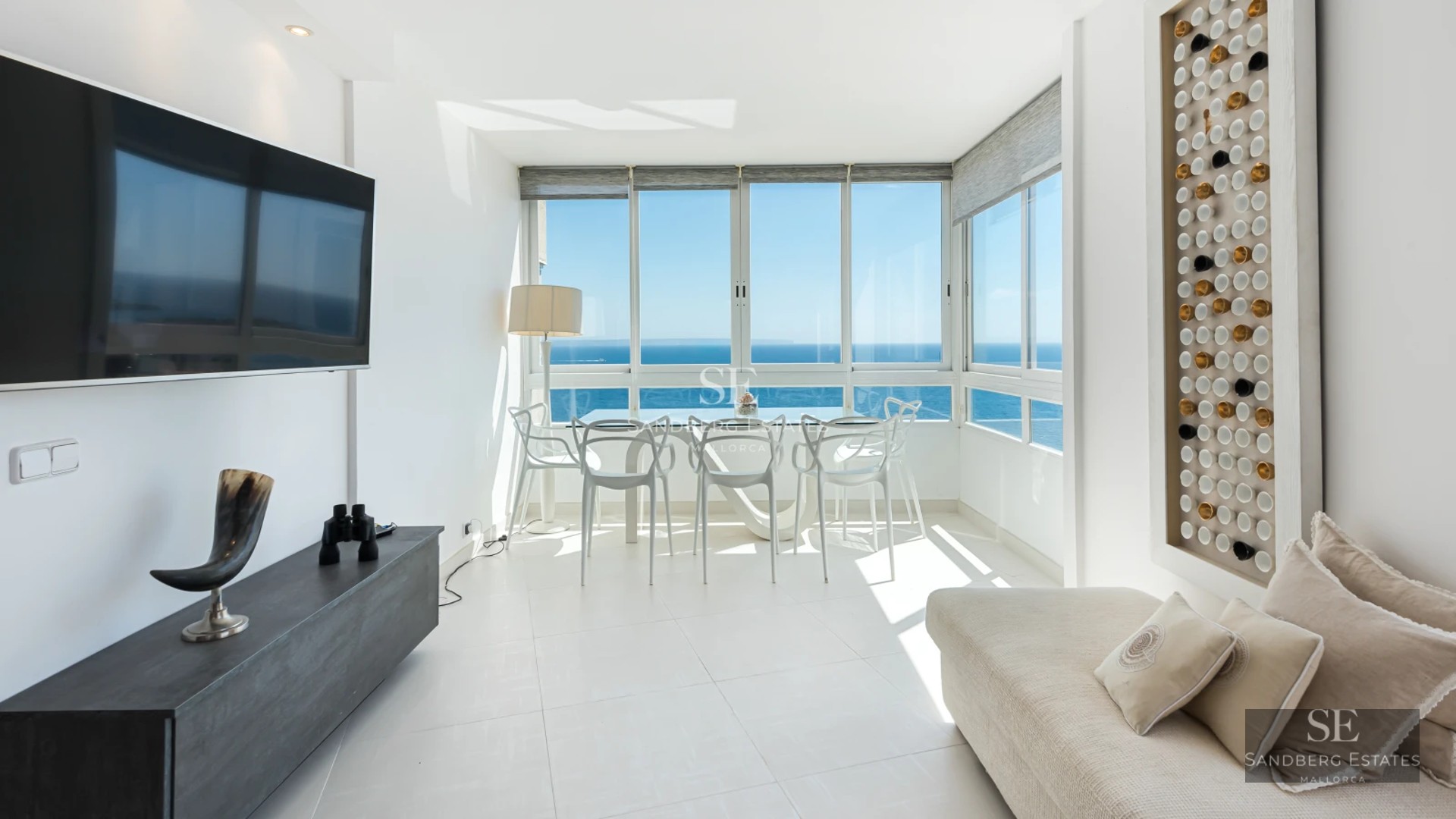 Spacious living room with balcony and sea view. Modern furniture, natural lighting, and neutral color palette. Elegant architecture.