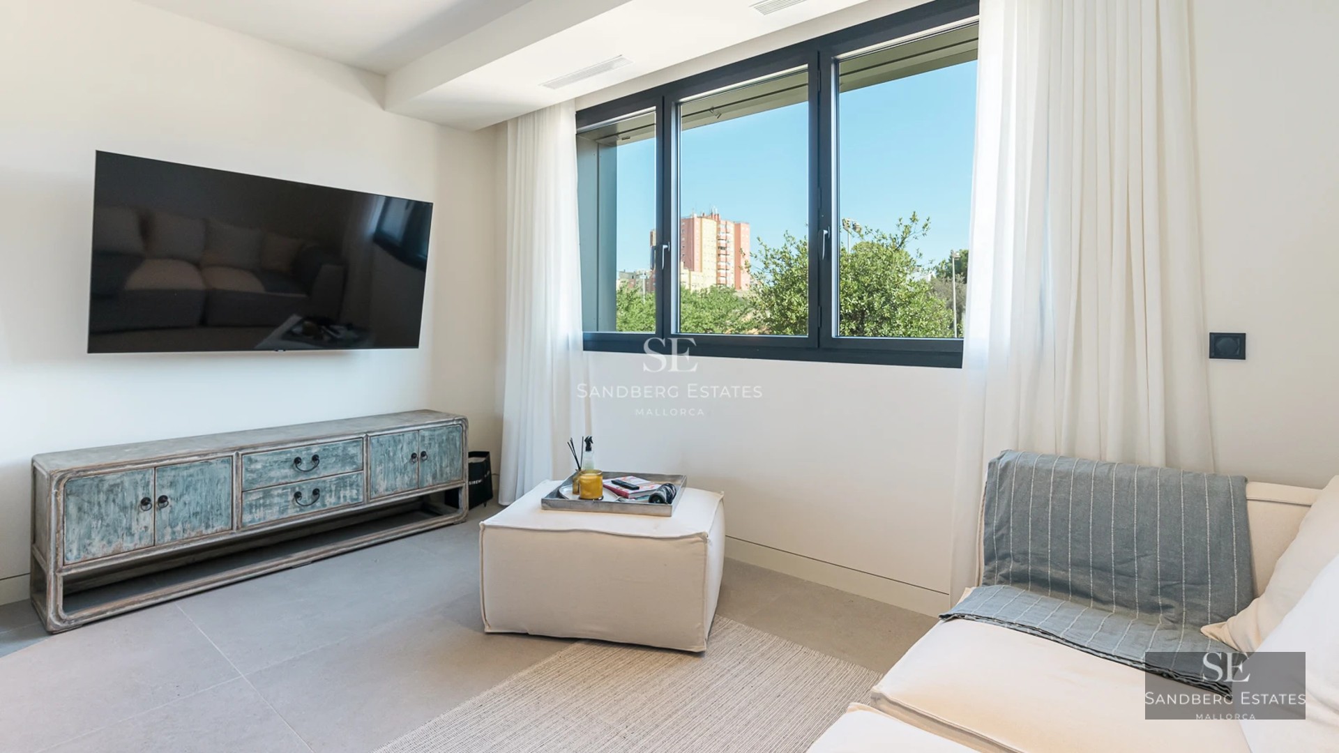 Bright living room with sea view. Large windows, modern design, glazed balcony. Elegant and minimalist interior.