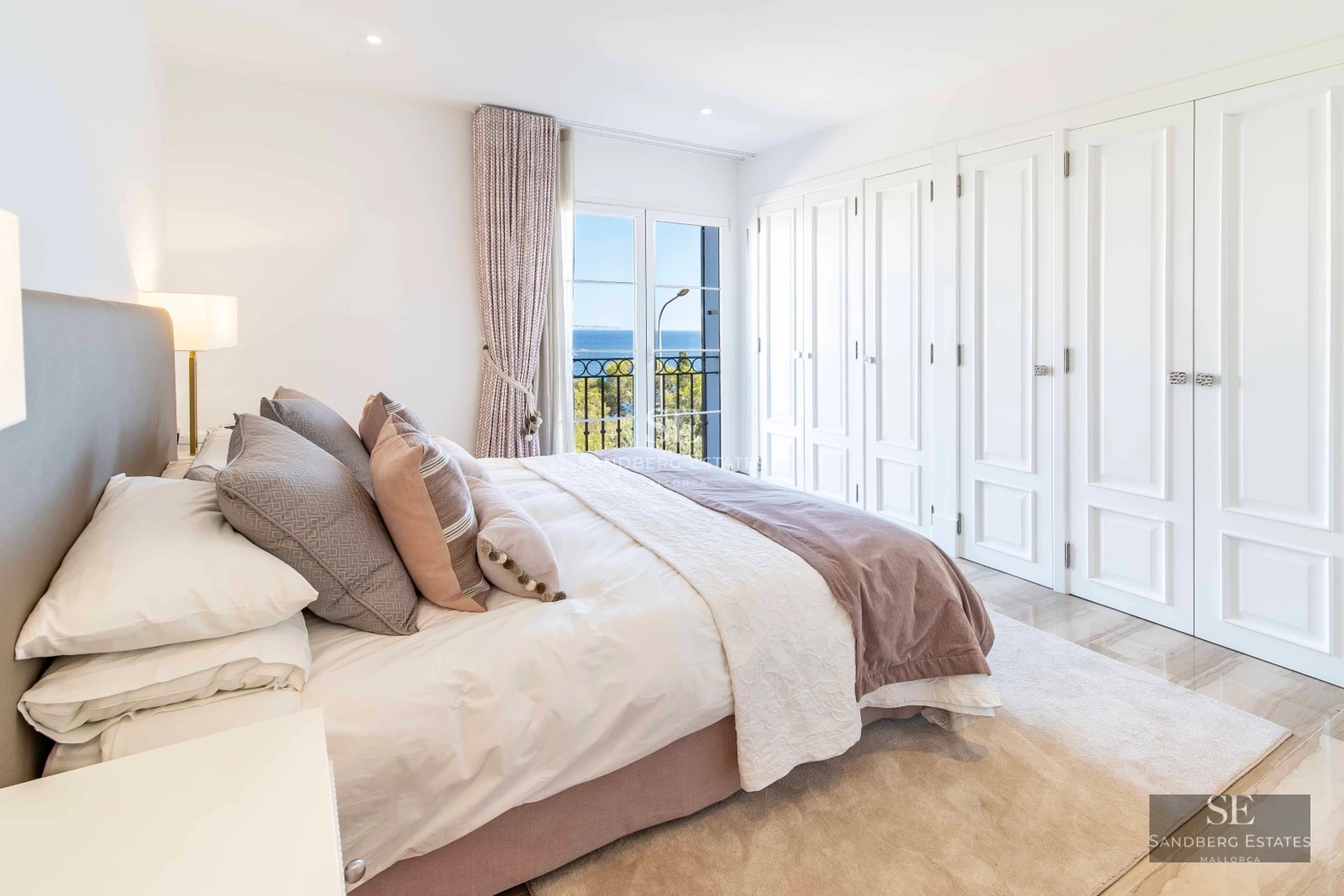 Spacious living room with fireplace, panoramic windows, and terrace access. Modern furnishings and elegant decor. Warm lighting.