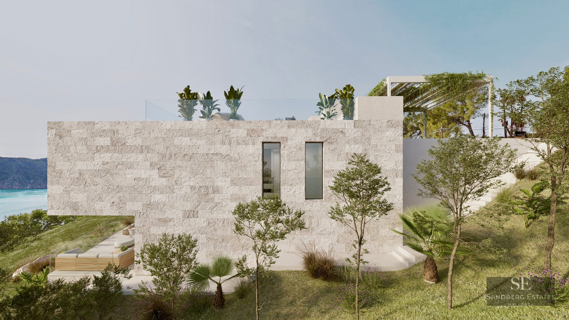 Side view of a modern luxury villa with textured stone walls, rooftop terrace, and Mediterranean landscaping overlooking the sea.