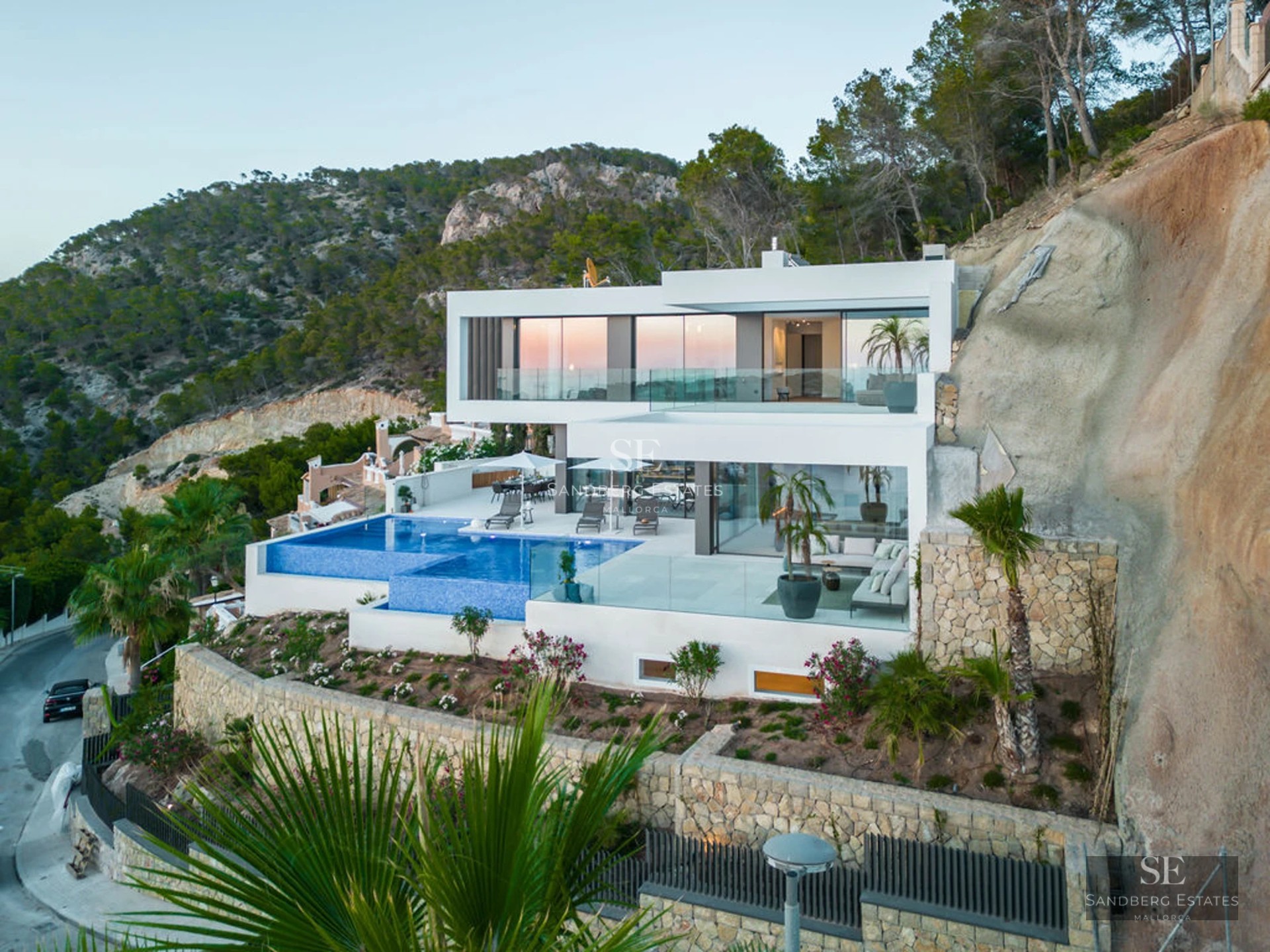 Exterior view of modern villa with pool, garden and expansive terraces. Sleek, minimalist design. Abundance of natural light.