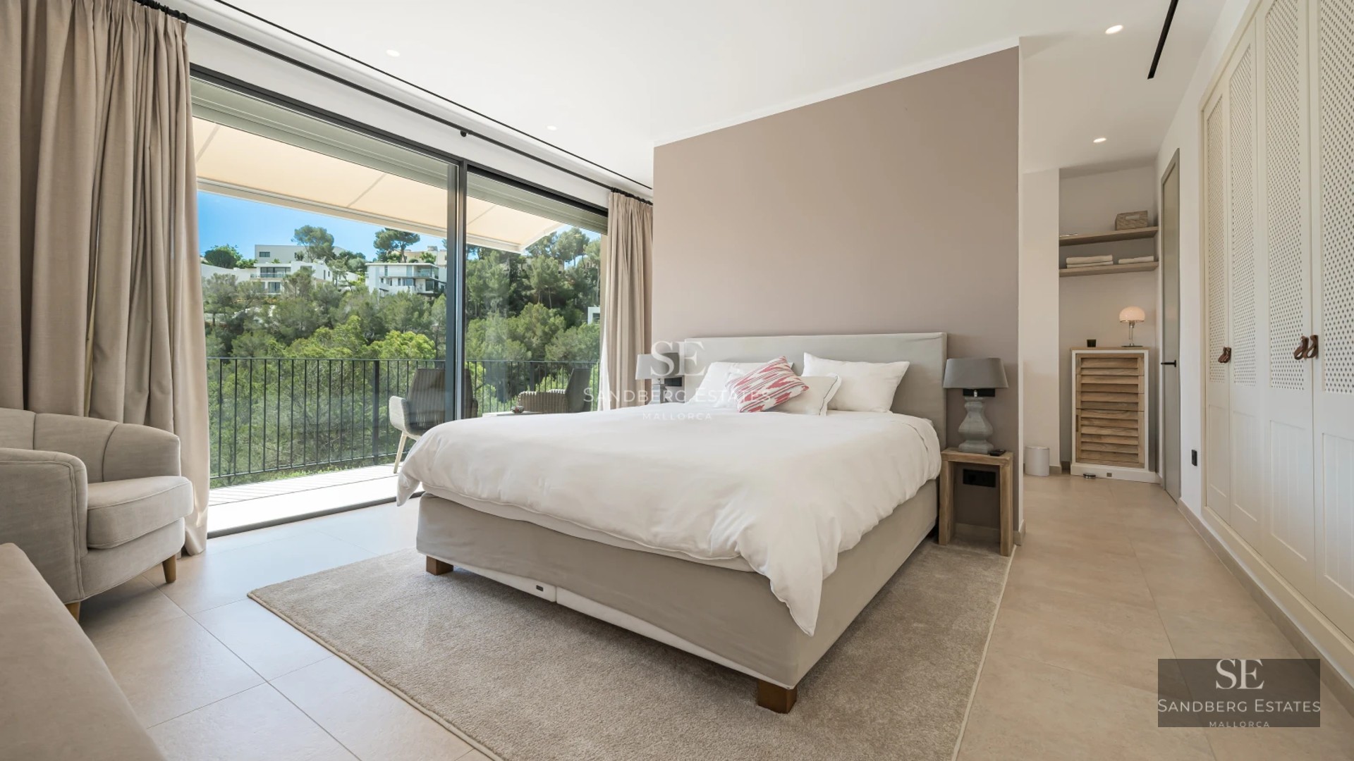 Spacious living room with floor-to-ceiling windows, modern fireplace, designer sofas, warm lighting, and access to a terrace with views.