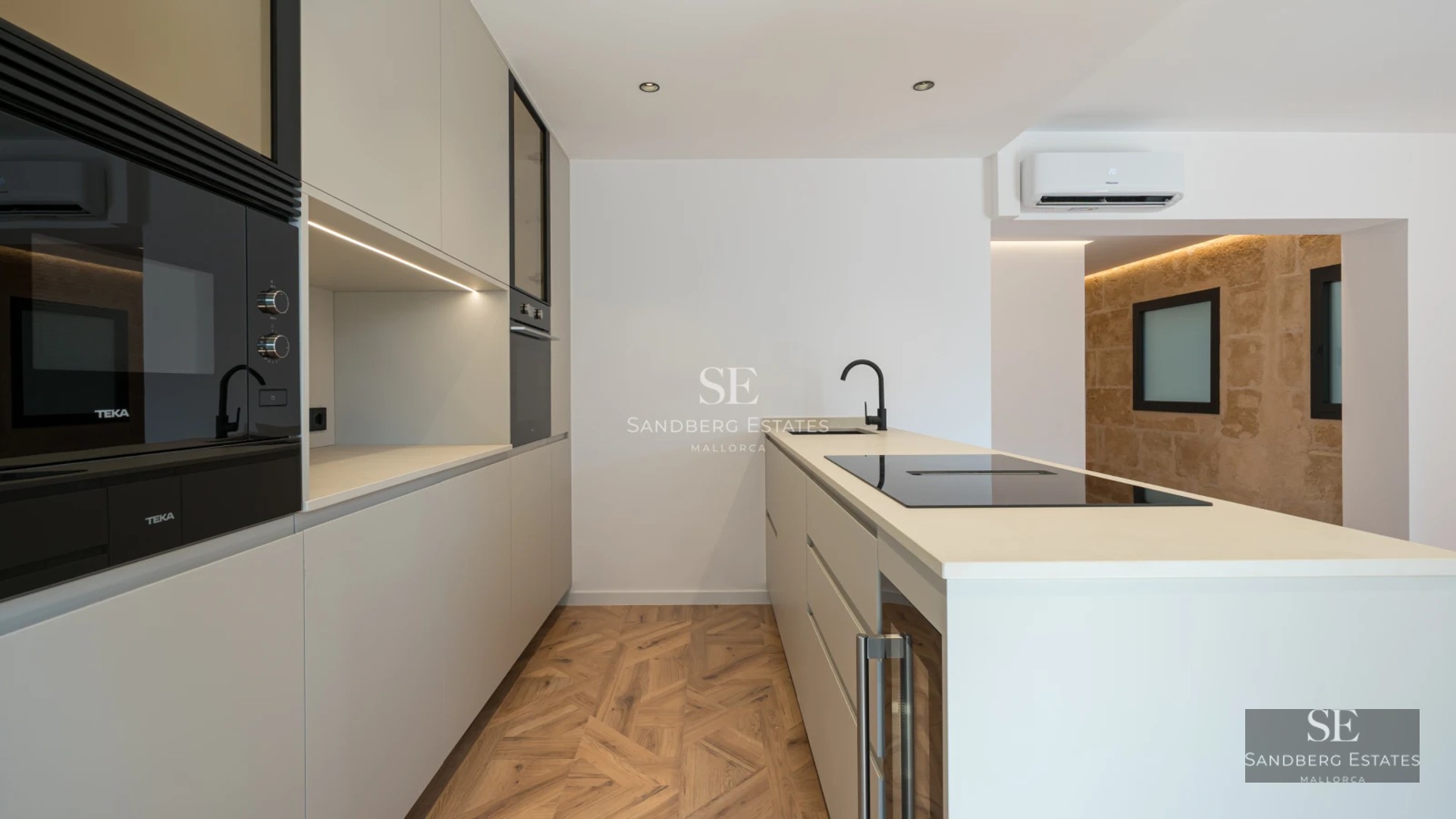 Bright living room with balcony, modern fireplace, light wood floors, and large windows offering panoramic views.