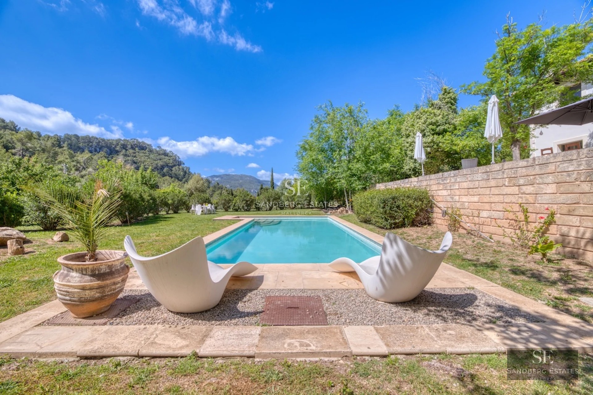 Spacious living room with picture windows, modern fireplace, and designer furniture. Panoramic views. Minimalist decor in neutral tones.
