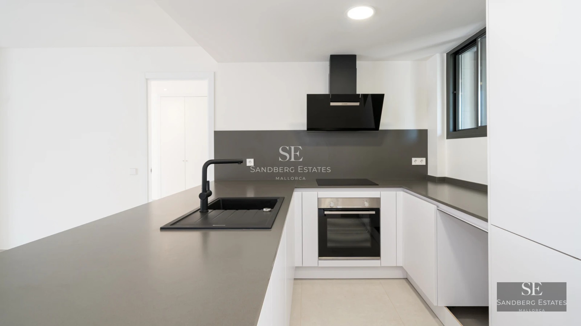 Bright living room leading to a balcony with sea views. Modern design, wooden floors, and elegant furniture. Large windows.