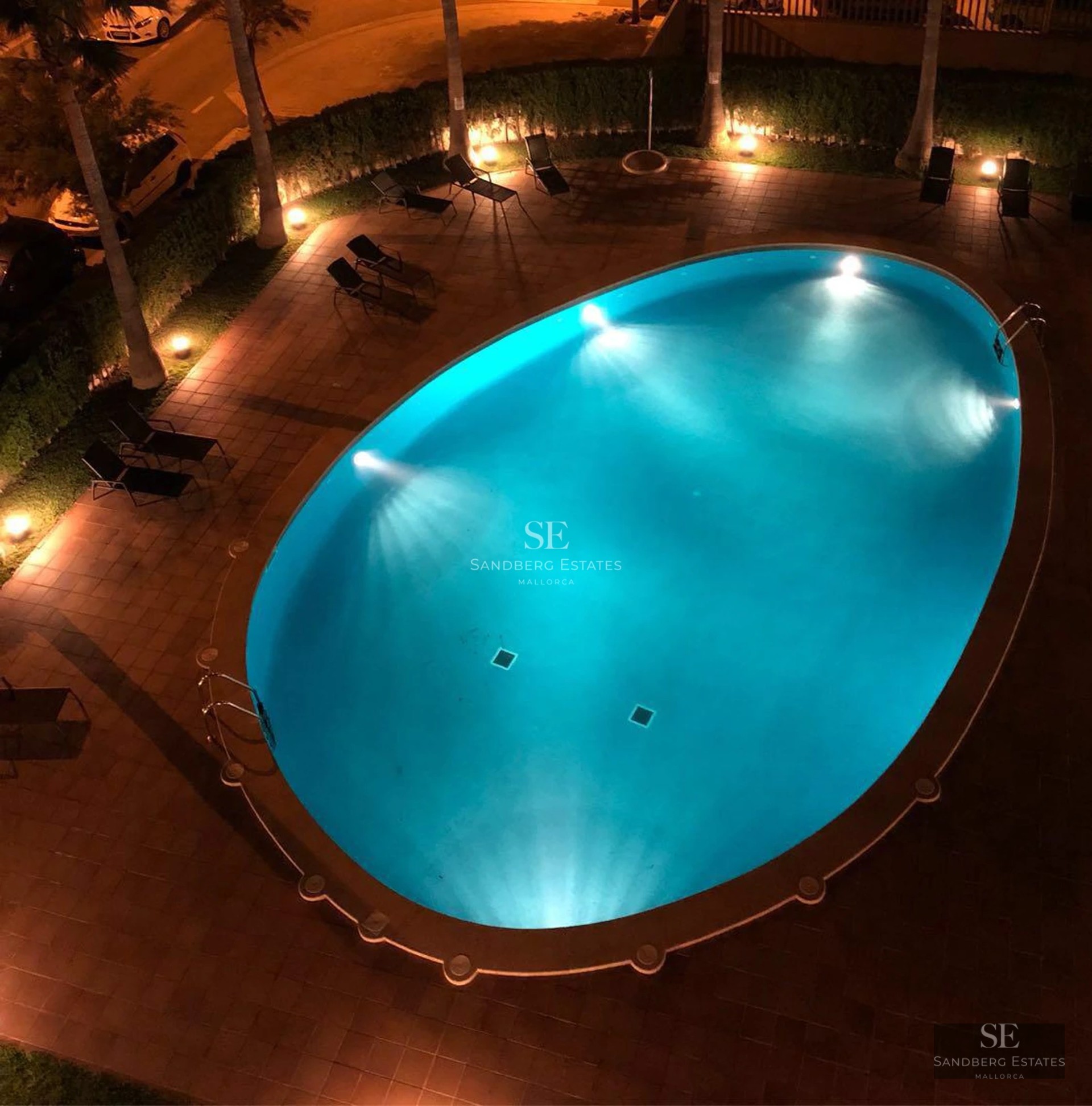 Vue d'une villa moderne avec piscine à débordement, mobilier extérieur élégant et vues panoramiques. Design minimaliste, vastes terrasses.