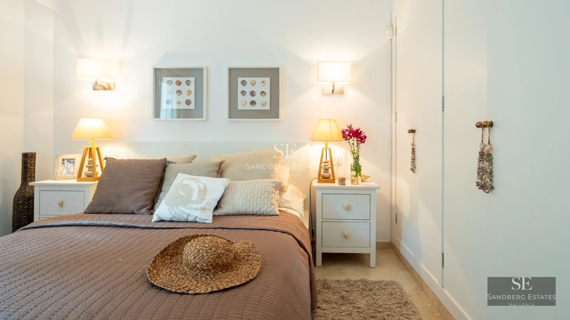 View of a luxurious pool with lounge chairs and lush vegetation. Modern architecture with large windows and minimalist design.